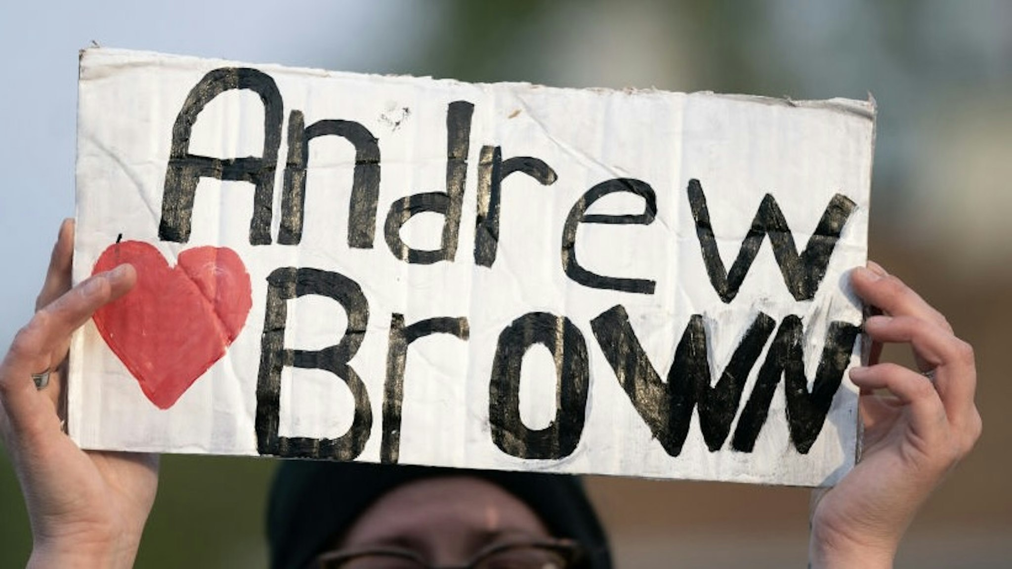 ELIZABETH CITY, NC - APRIL 22: A demonstrator holds a sign for Andrew Brown Jr. during a protest march on April 22, 2021 in Elizabeth City, North Carolina. The protest was sparked by the police killing of Brown on April 21. (Photo by Sean Rayford/Getty Images)