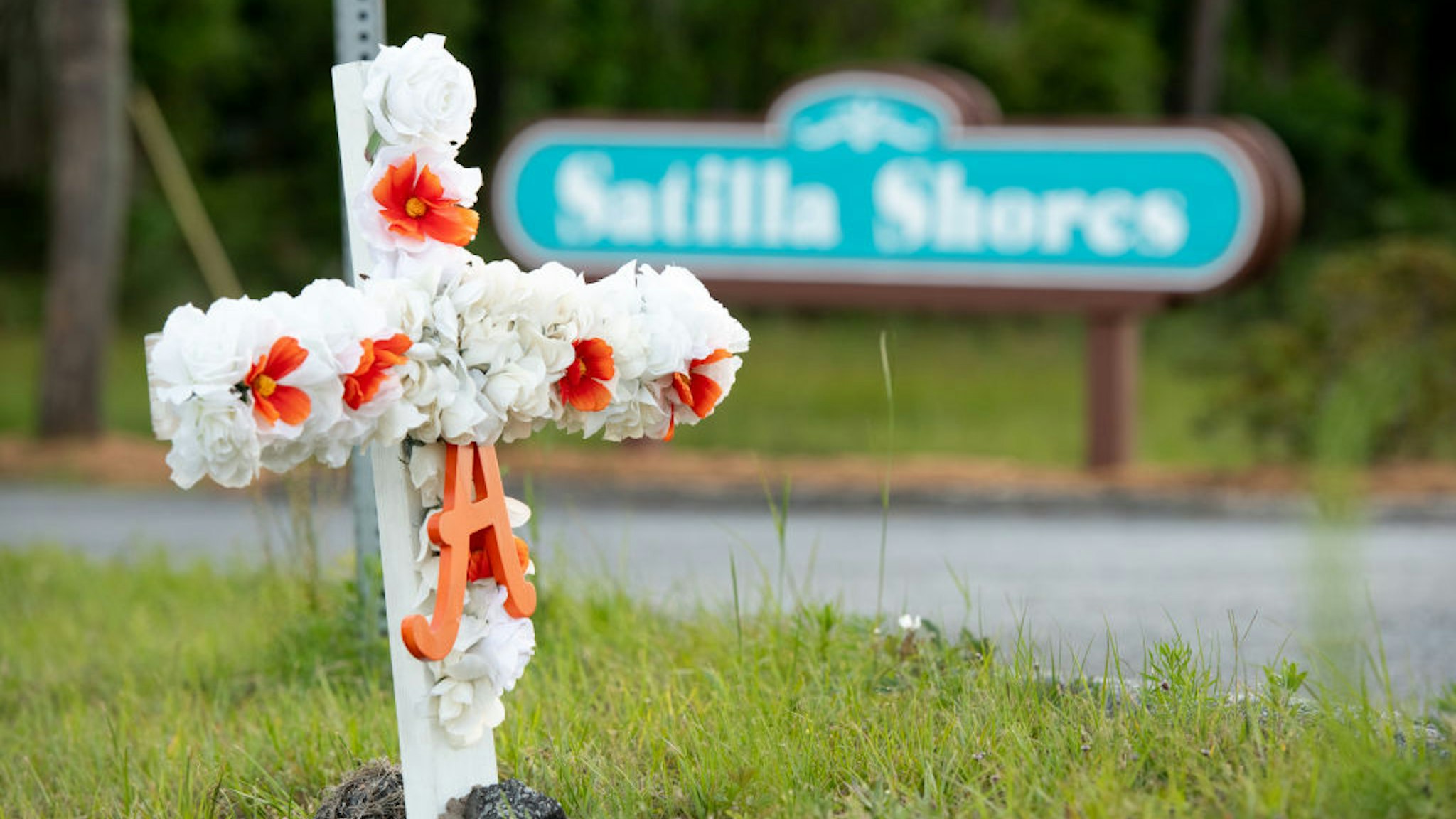 BRUNSWICK, GA - MAY 06: A cross with flowers and a letter "A" sits at the entrance to the Satilla Shores neighborhood where Ahmaud Arbery was shot and killed on May 6, 2020 in Brunswick, Georgia. Attorneys for Arbery released a video that appears to show the 25-year-old being gunned down while jogging during a confrontation with an armed father and son on February 23.