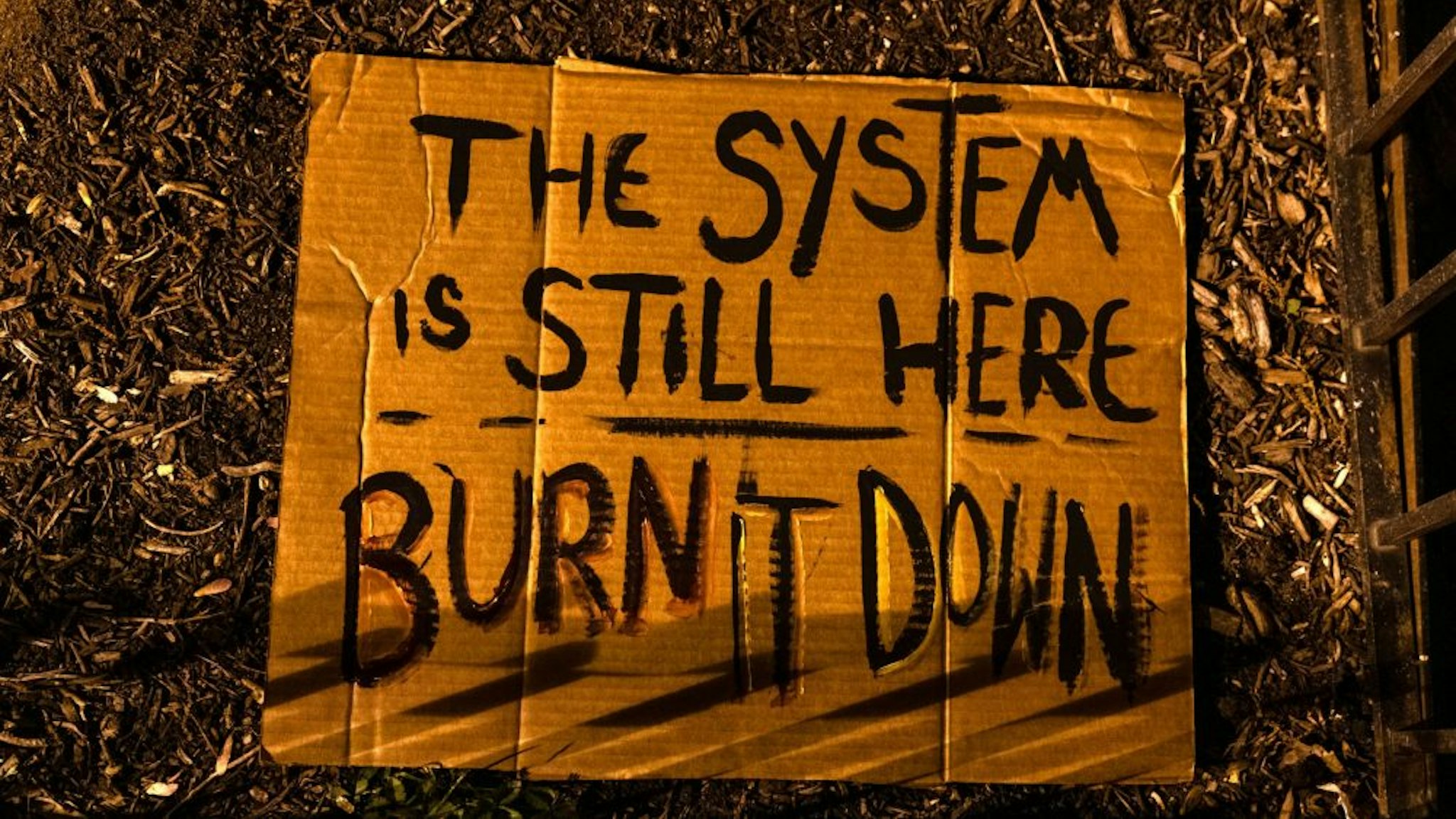 A sign reading "The system is still here. Burn it down." at Black Lives Matter Plaza in Washington, D.C., U.S., on Tuesday, April 20, 2021. Former Minneapolis police officer Derek Chauvin was found guilty of killing George Floyd when he knelt on the mans neck for 9 minutes and 29 seconds, a videotaped death that ignited a summer of rage and the greatest racial reckoning in the U.S. since the 1960s.