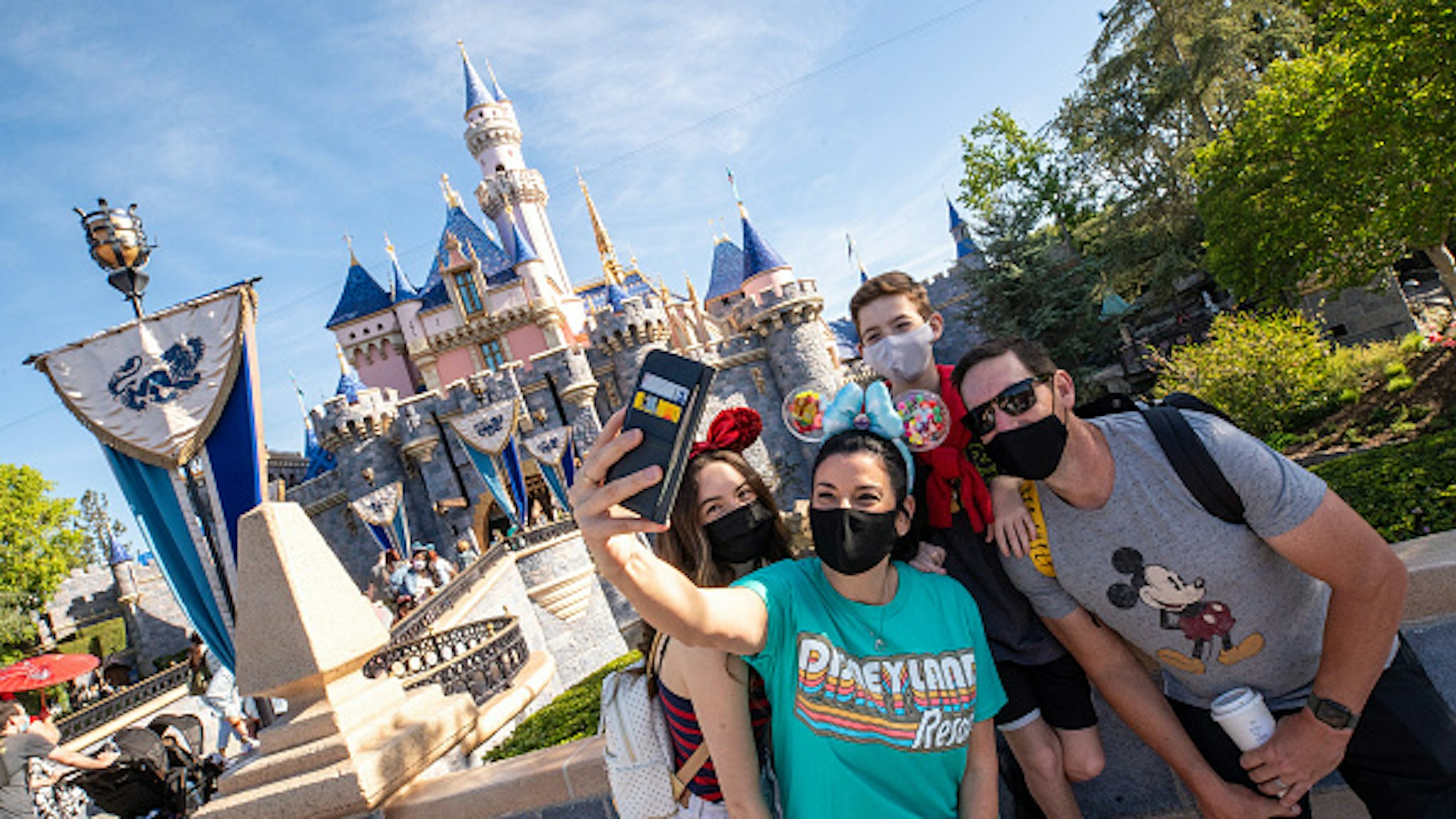 ANAHEIM, CA - APRIL 30: In this handout photo provided by Disneyland Resort, The Wotter family of Lake Elsinore, California, takes a selfie photo in front of Sleeping Beauty Castle as Disneyland Park at the Disneyland Resort on April 30, 2021 in Anaheim, California. Guests are being welcomed back as Disneyland Park, Disney California Adventure Park and Disney's Grand Californian Hotel &amp; Spa are reopening