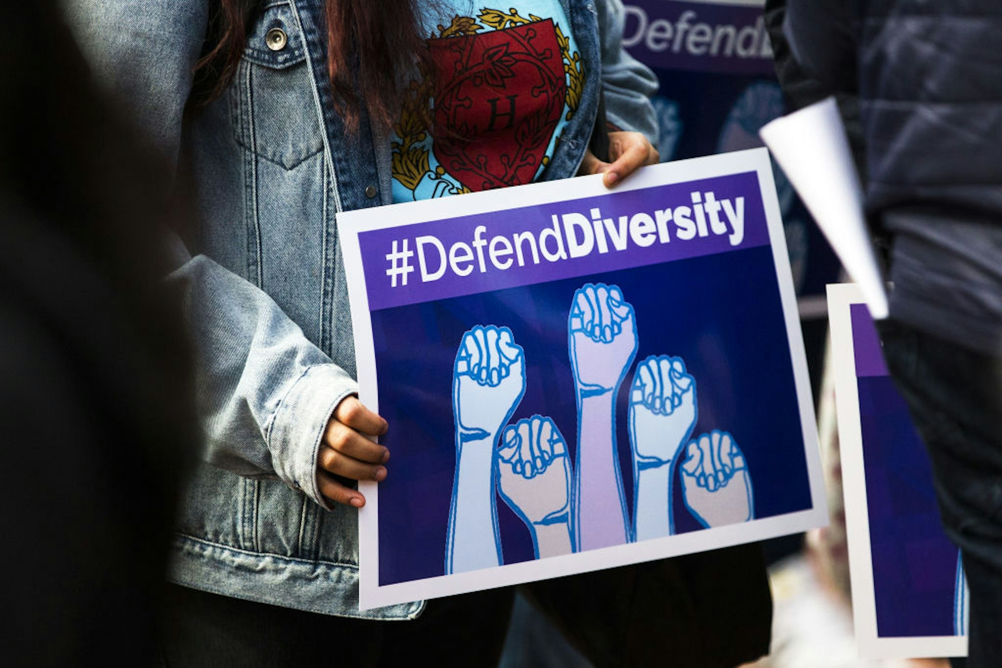 A demonstrator supporting Harvard University's admission process holds a sign that reads "Defend Diversity" during a protest outside of the Massachusetts Bay Transportation Authority (MBTA) Harvard station in Cambridge, Massachusetts, U.S., on Sunday, Oct. 14, 2018. Harvard University was sued by a group that claims their law school illegally used race and gender as criteria for selecting law students to staff their most elite academic journals, a suit that comes amid growing scrutiny of affirmative action in college admissions.