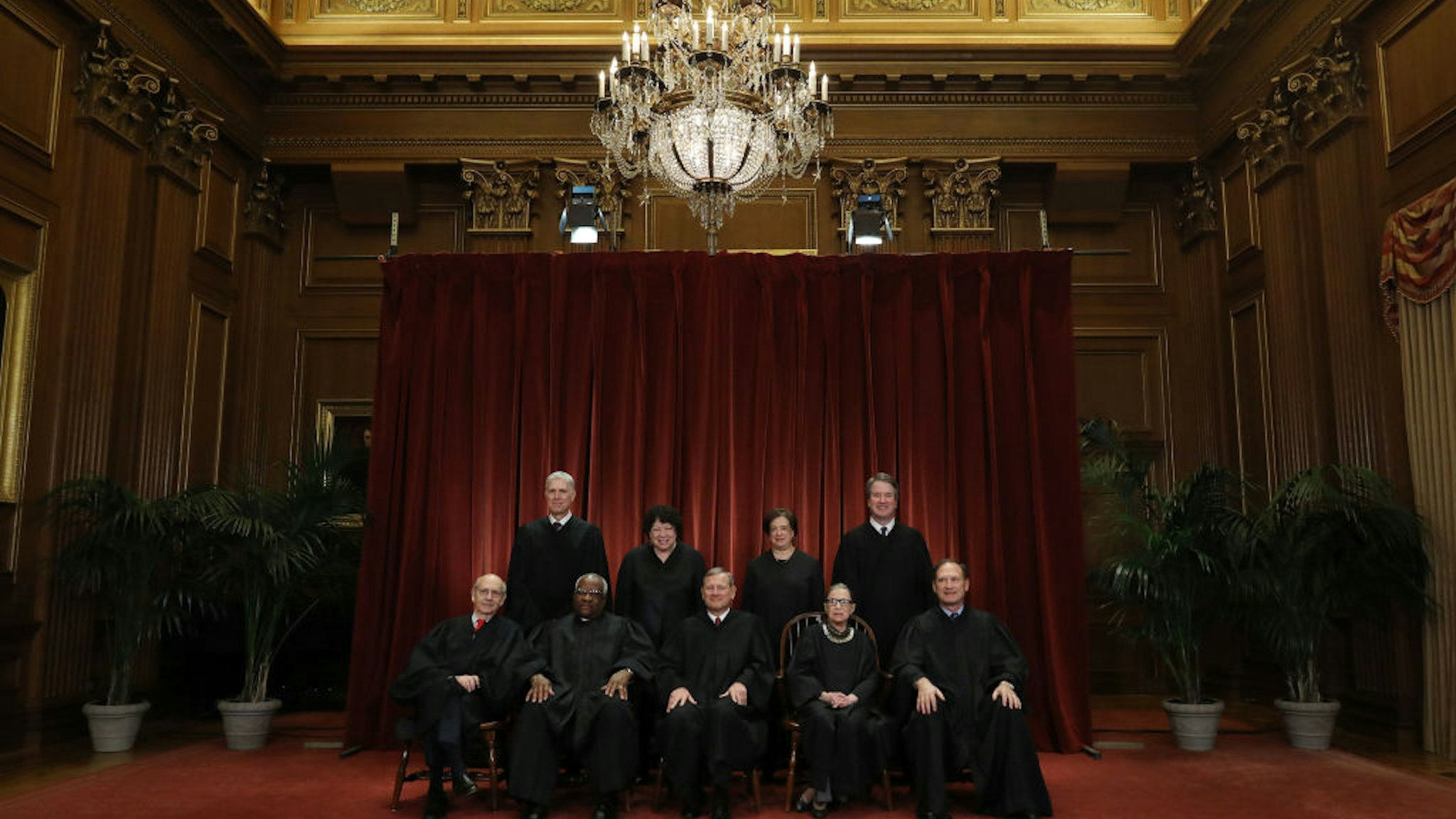 WASHINGTON, DC - NOVEMBER 30: United States Supreme Court (Front L-R) Associate Justice Stephen Breyer, Associate Justice Clarence Thomas, Chief Justice John Roberts, Associate Justice Ruth Bader Ginsburg, Associate Justice Samuel Alito, Jr., (Back L-R) Associate Justice Neil Gorsuch, Associate Justice Sonia Sotomayor, Associate Justice Elena Kagan and Associate Justice Brett Kavanaugh pose for their official portrait at the in the East Conference Room at the Supreme Court building November 30, 2018 in Washington, DC. Earlier this month, Chief Justice Roberts publicly defended the independence and integrity of the federal judiciary against President Trump after he called a judge who had ruled against his administration’s asylum policy “an Obama judge.” “We do not have Obama judges or Trump judges, Bush judges or Clinton judges,” Roberts said in a statement. “What we have is an extraordinary group of dedicated judges doing their level best to do equal right to those appearing before them. That independent judiciary is something we should all be thankful for.” (Photo by Chip Somodevilla/Getty Images)