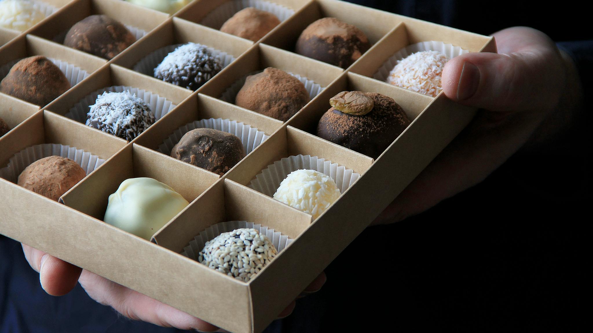 box of chocolates in male hands on a dark background box of chocolates in male hands on a dark background