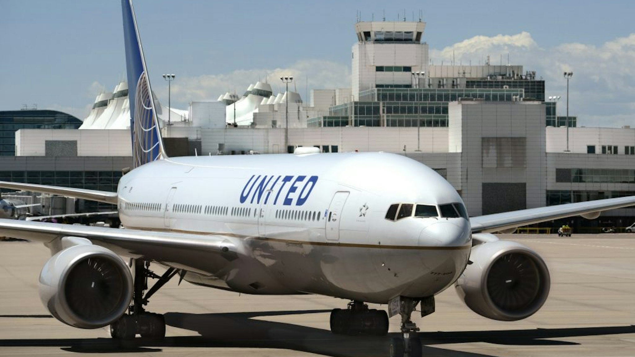 DENVER, COLORADO - JUNE 20, 2019: A United Airlines Boeing 777 passenger aircraft taxis into its gate at Denver International Airport in Denver, Colorado.