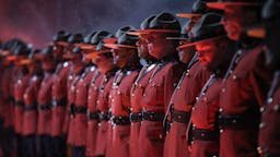 Uniformed Royal Canadian Mounted Police officers line up in a Wall of Honour before the Calgary Flames take on the Winnipeg Jets during the 2019 Tim Hortons NHL Heritage Classic at Mosaic Stadium on October 26, 2019 in Regina, Saskatchewan, Canada Uniformed Royal Canadian Mounted Police officers line up in a Wall of Honour before the Calgary Flames take on the Winnipeg Jets during the 2019 Tim Hortons NHL Heritage Classic at Mosaic Stadium on October 26, 2019 in Regina, Saskatchewan, Canada
