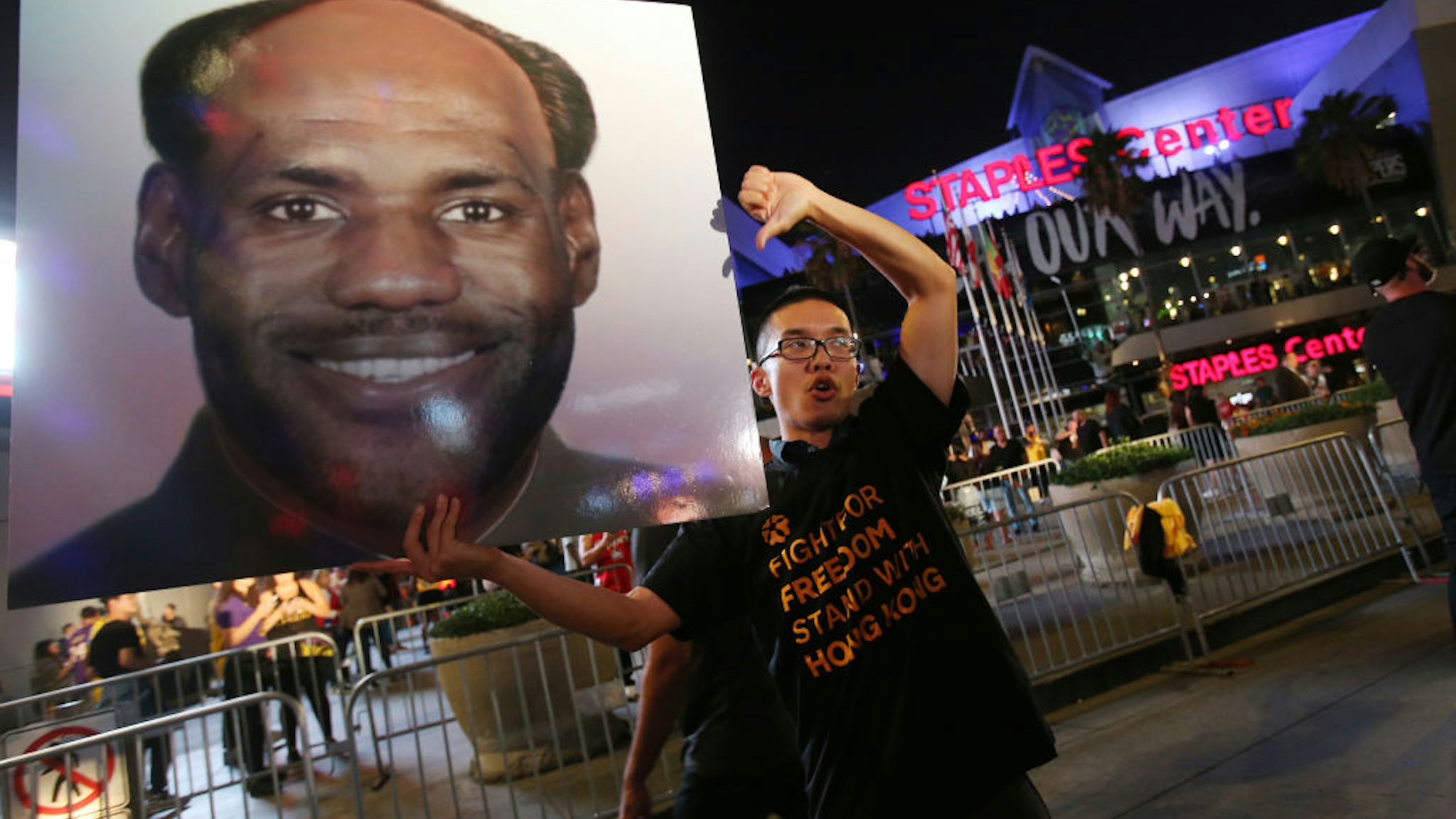 LOS ANGELES, CALIFORNIA - OCTOBER 22: A pro-Hong Kong activist holds a photo depicting LeBron James as Chinese communist revolutionary Chairman Mao Zedong before the Los Angeles Lakers season opening game against the LA Clippers, outside Staples Center, on October 22, 2019 in Los Angeles, California. Activists also printed 16,000 pro-Hong Kong t-shirts to hand out to those attending the game and encouraged them to wear the free shirts as a form of peaceful protest against China amidst Chinese censorship of NBA games. (Photo by Mario Tama/Getty Images)