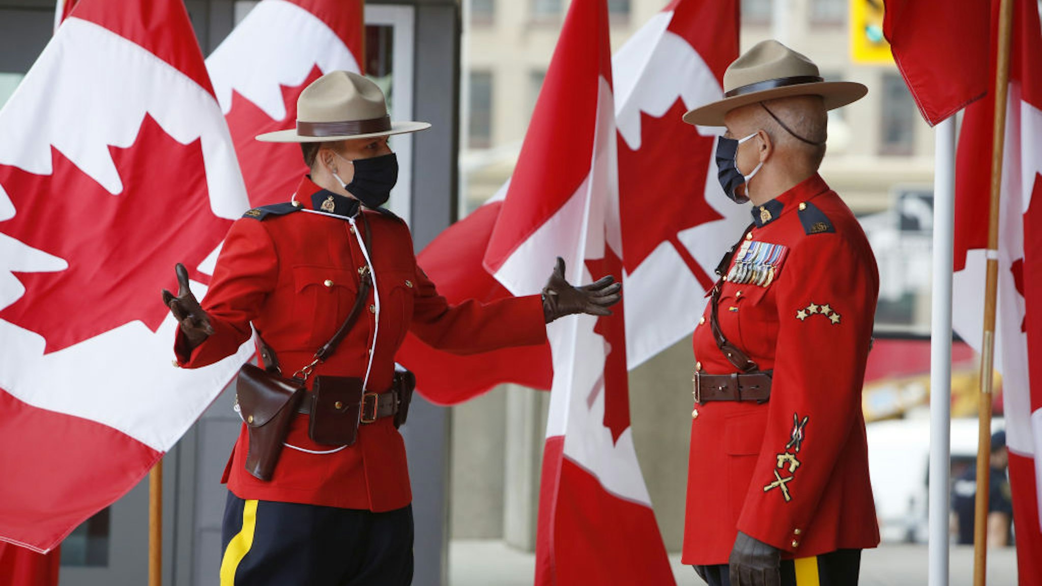 Royal Canadian Mounted Police officers (RCMP) wearing protective masks stand outside the Senate of Canada before the Throne Speech in Ottawa, Ontario, Canada, on Wednesday, Sept. 23, 2020. Prime Minister Justin Trudeau says his government will launch a campaign to create 1 million jobs in Canada, returning employment to pre-pandemic levels