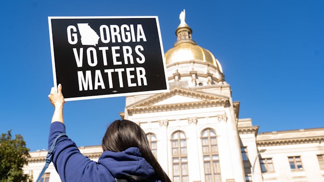 ATLANTA, GA - MARCH 03: Demonstrators stand outside of the Georgia Capitol building, to oppose the HB 531 bill on March 3, 2021 in Atlanta, Georgia. HB 531 will add controversial voting restrictions to the state's upcoming elections including restricting ballot drop boxes, requiring an ID requirement for absentee voting and limiting weekend early voting days. The Georgia House passed the bill and will send it to the Senate. (Photo by Megan Varner/Getty Images)