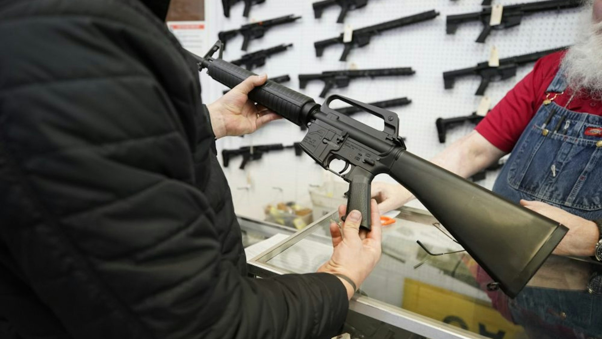 A salesperson shows an AR-15 rifle to a customer at a store in Orem, Utah, U.S., on Thursday, March 25, 2021. Two mass shootings in one week are giving Democrats new urgency to pass gun control legislation, but opposition from Republicans in the Senate remains the biggest obstacle to any breakthrough in the long-stalled debate.