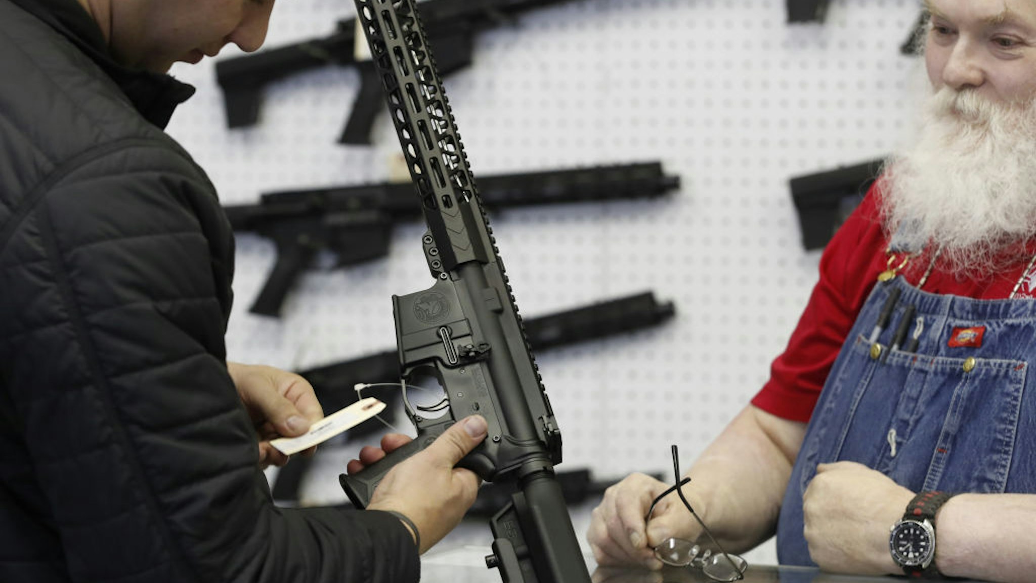 A salesperson shows an AR-15 rifle to a customer at a store in Orem, Utah, U.S., on Thursday, March 25, 2021. Two mass shootings in one week are giving Democrats new urgency to pass gun control legislation, but opposition from Republicans in the Senate remains the biggest obstacle to any breakthrough in the long-stalled debate. Photographer:
