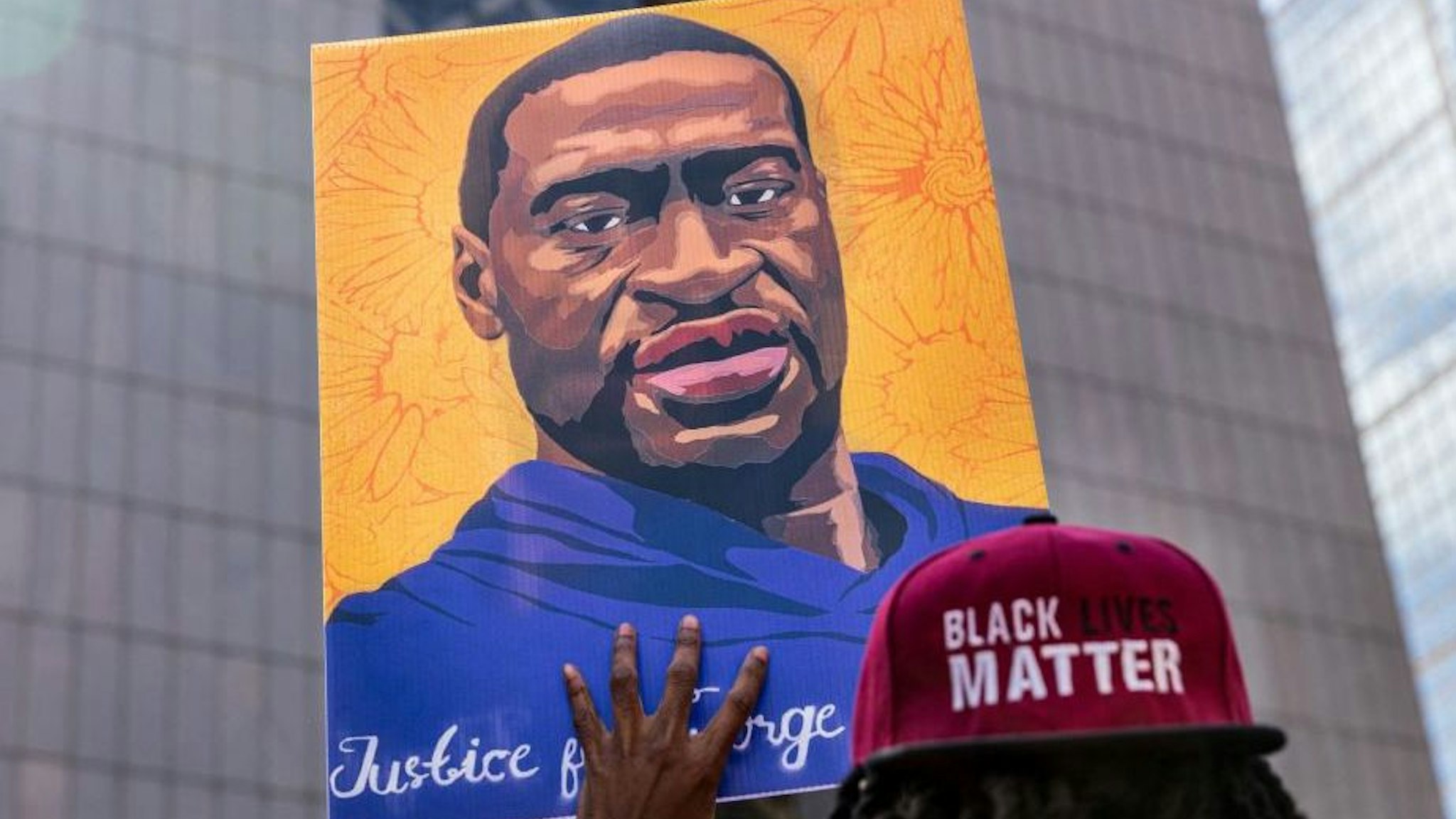 Demonstrators hold signs honouring George Floyd and other victims of racism as they gather during a protest outside Hennepin County Government Center on March 28, 2021 in Minneapolis, Minnesota.