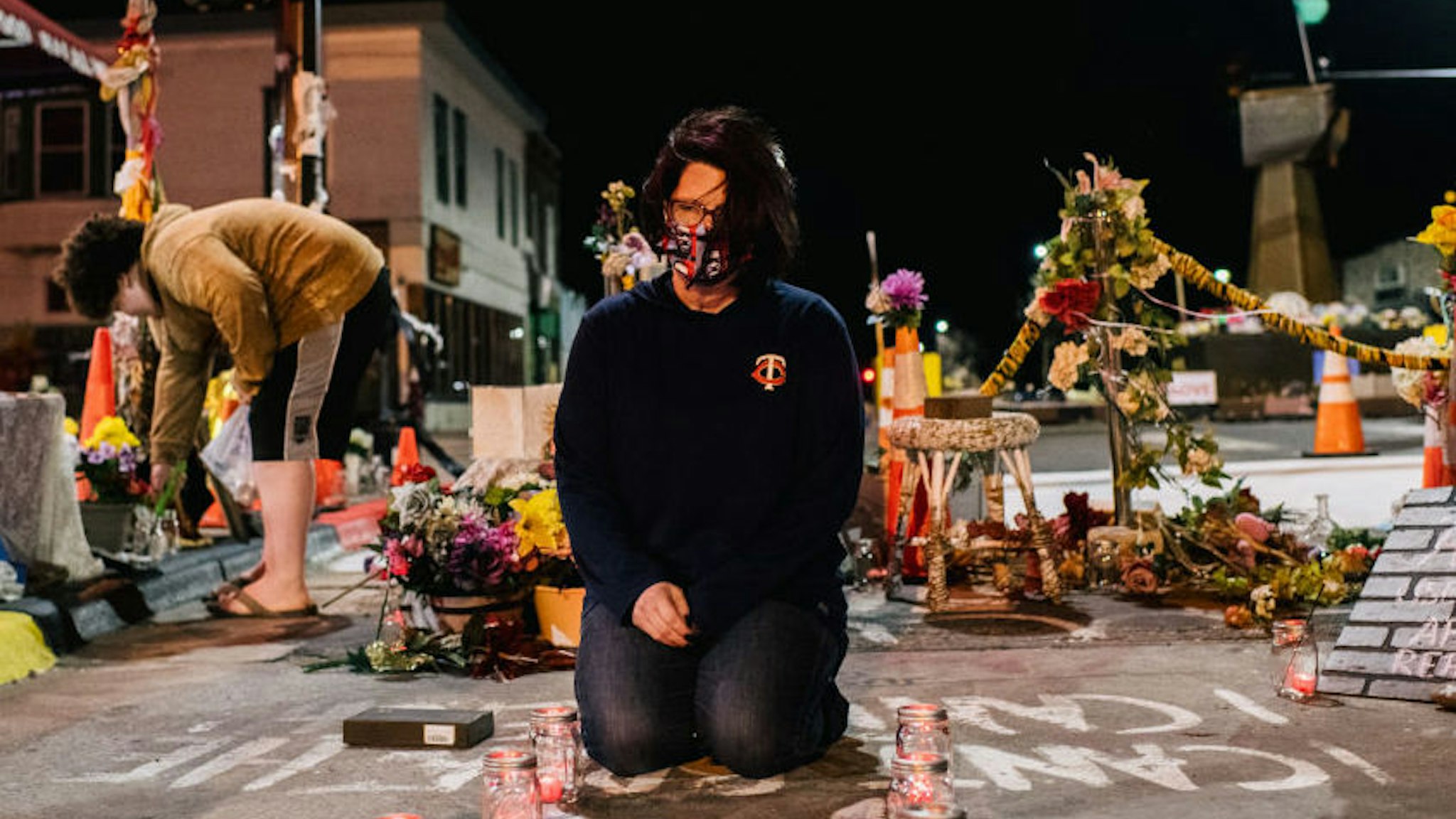 Courteney Ross, girlfriend of George Floyd, lays candles in the intersection of 38th St. & Chicago Ave on March 29, 2021 in Minneapolis, Minnesota.
