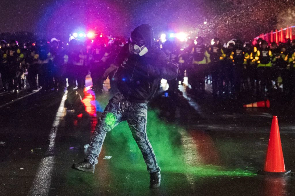 A demonstrator hit by a riot projectile gestures outside the Brooklyn Center police station as he protests the death of Daunte Wright who was shot and killed by a police officer in Brooklyn Center, Minnesota on April 13, 2021.