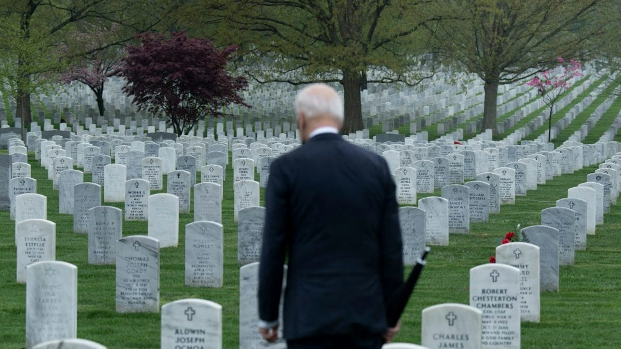 TOPSHOT - US President Joe Biden walks through Arlington National cemetary to honor fallen veterans of the Afghan conflict in Arlington, Virginia on April 14, 2021. - President Joe Biden announced it's "time to end" America's longest war with the unconditional withdrawal of troops from Afghanistan, where they have spent two decades in a bloody, largely fruitless battle against the Taliban.