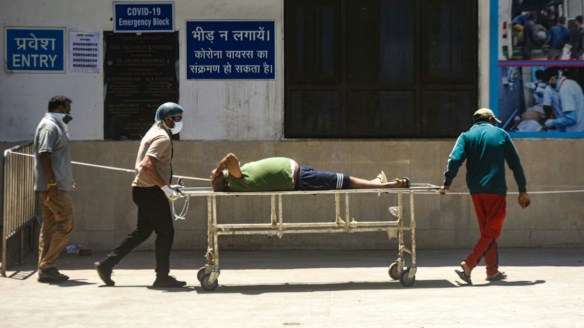 NEW DELHI, INDIA APRIL 24: Relatives carry a Covid-19 patient on a stretcher as they leave from GTB Hospital , on April 24, 2021 in New Delhi, India. (Photo by Amal KS/Hindustan Times via Getty Images)
