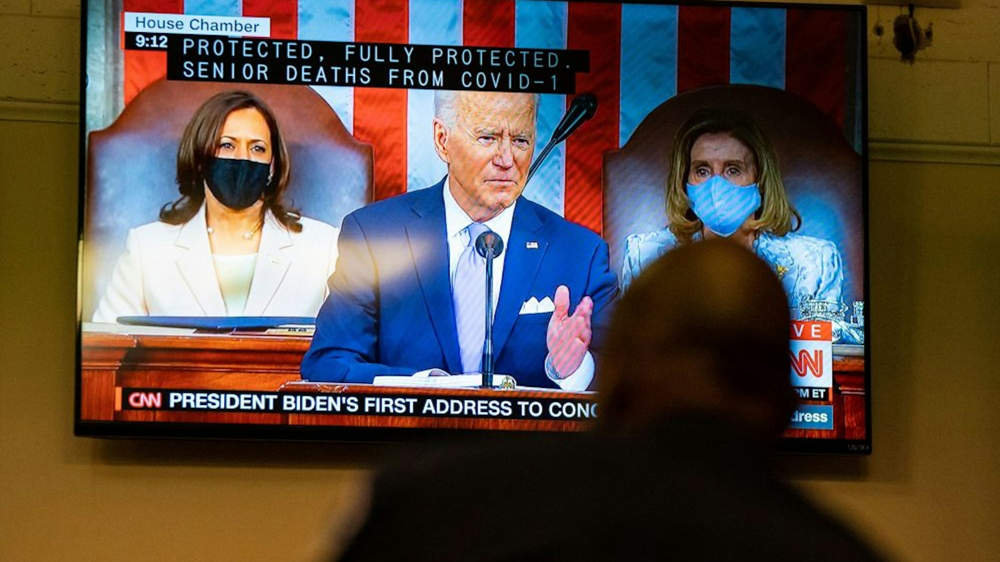 WASHINGTON, DC - APRIL 28: A Capitol Police Officer watches President Joe Bidens address of the Joint Session of the 117th Congress on a television in the Senate Press Gallery, at the U.S. Capitol Building on Wednesday, April 28, 2021 in Washington, DC.