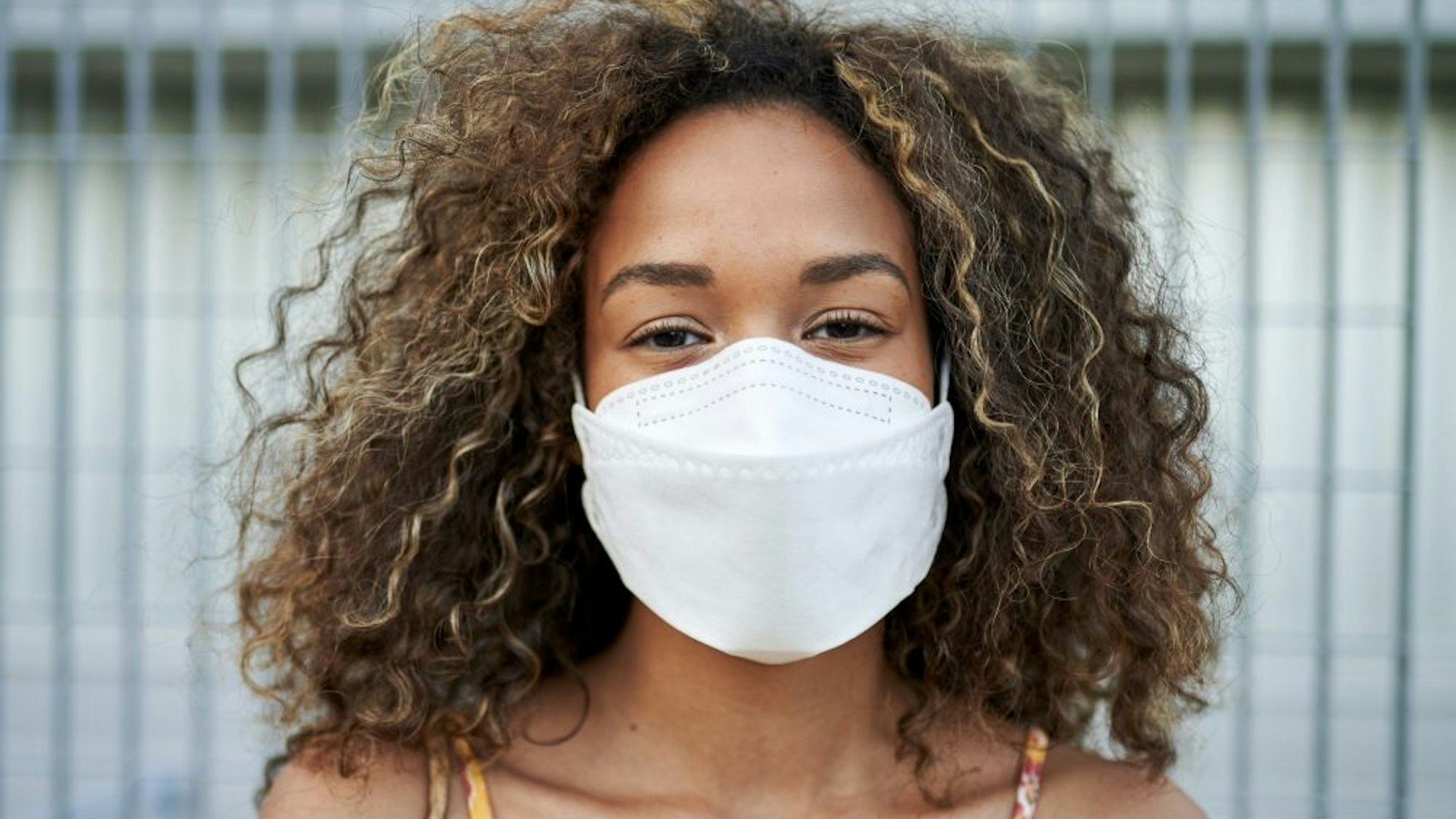 Portrait of young woman with antiviral mask outdoors