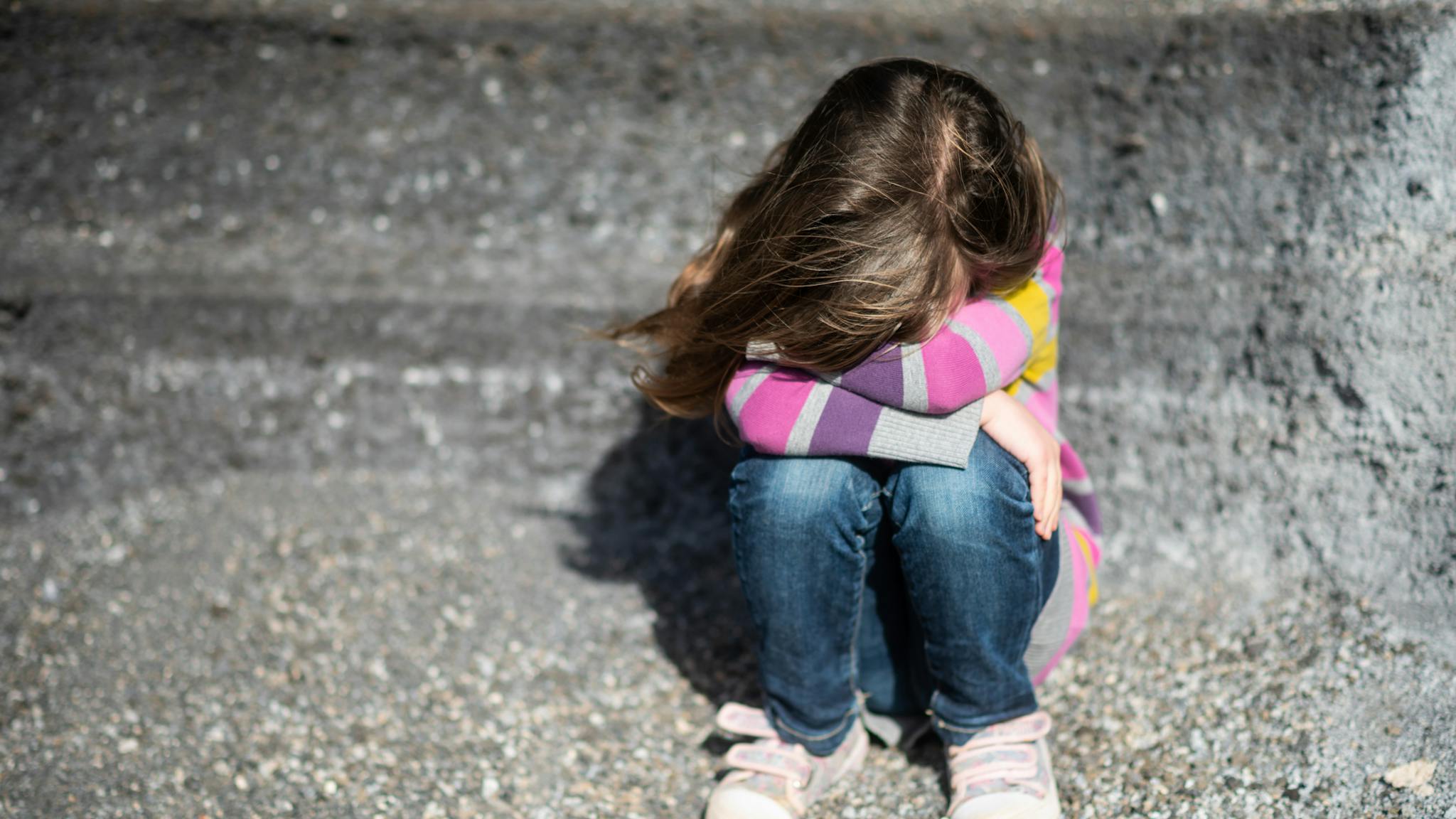 Isolated kid hiding her face from camera Isolated kid hiding her face from camera - stock photo