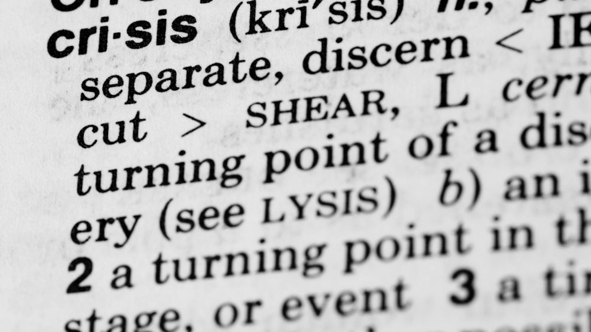 "Dictionary Definition of the word Crisis. Shallow Depth of Field, focus on the word Crisis. Desaturated Color."