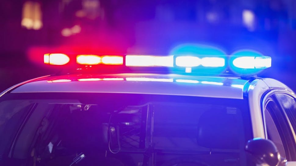 The roof of a police patrol car at night, with the blue and red lights flashing.