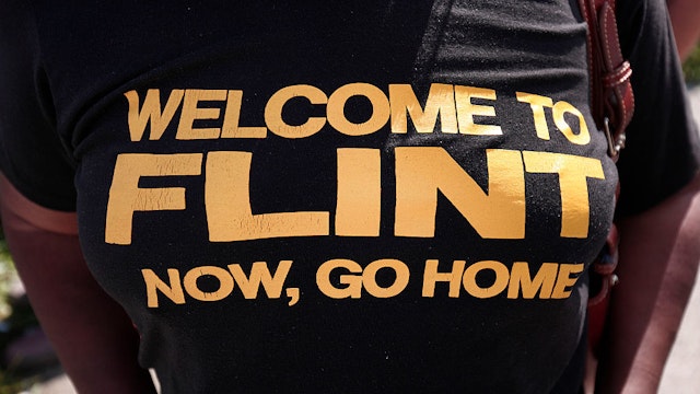 FLINT, MI - SEPTEMBER 14: An anti-Trump protestor wears a shirt that expresses her opinion while waiting for Republican presidential nominee Donald Trump to arrive for a visit to the Flint Water Treatment Plant September 14, 2016 in Flint, Michigan. While in Flint, Trump will also meet with several ministers from the area.