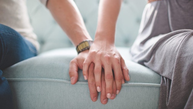 Waist photo of man and woman holding hands