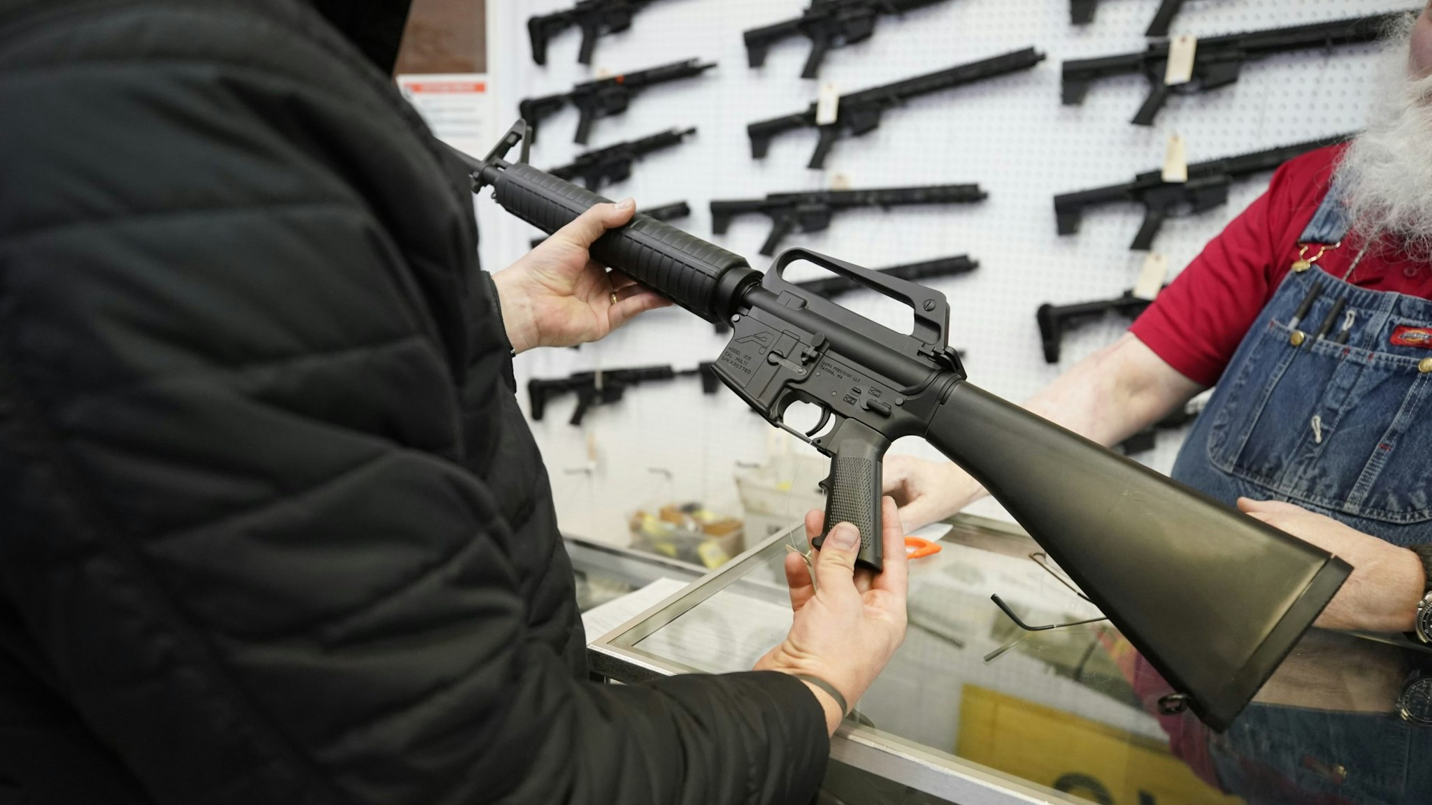 A salesperson shows an AR-15 rifle to a customer at a store in Orem, Utah, U.S., on Thursday, March 25, 2021. Two mass shootings in one week are giving Democrats new urgency to pass gun control legislation, but opposition from Republicans in the Senate remains the biggest obstacle to any breakthrough in the long-stalled debate.