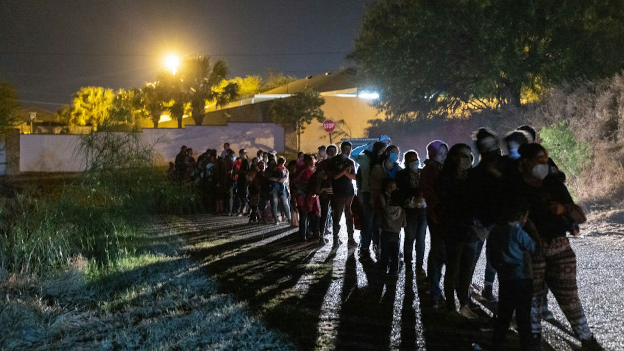 ROMA, TEXAS - APRIL 10: Central American immigrants wait to be processed by U.S. Border Patrol agents after they crossed the Rio Grande from Mexico early on April 10, 2021 in Roma, Texas. A surge of immigrants crossing into the United States, including record numbers of children, has challenged U.S. immigration agencies along the southern border.