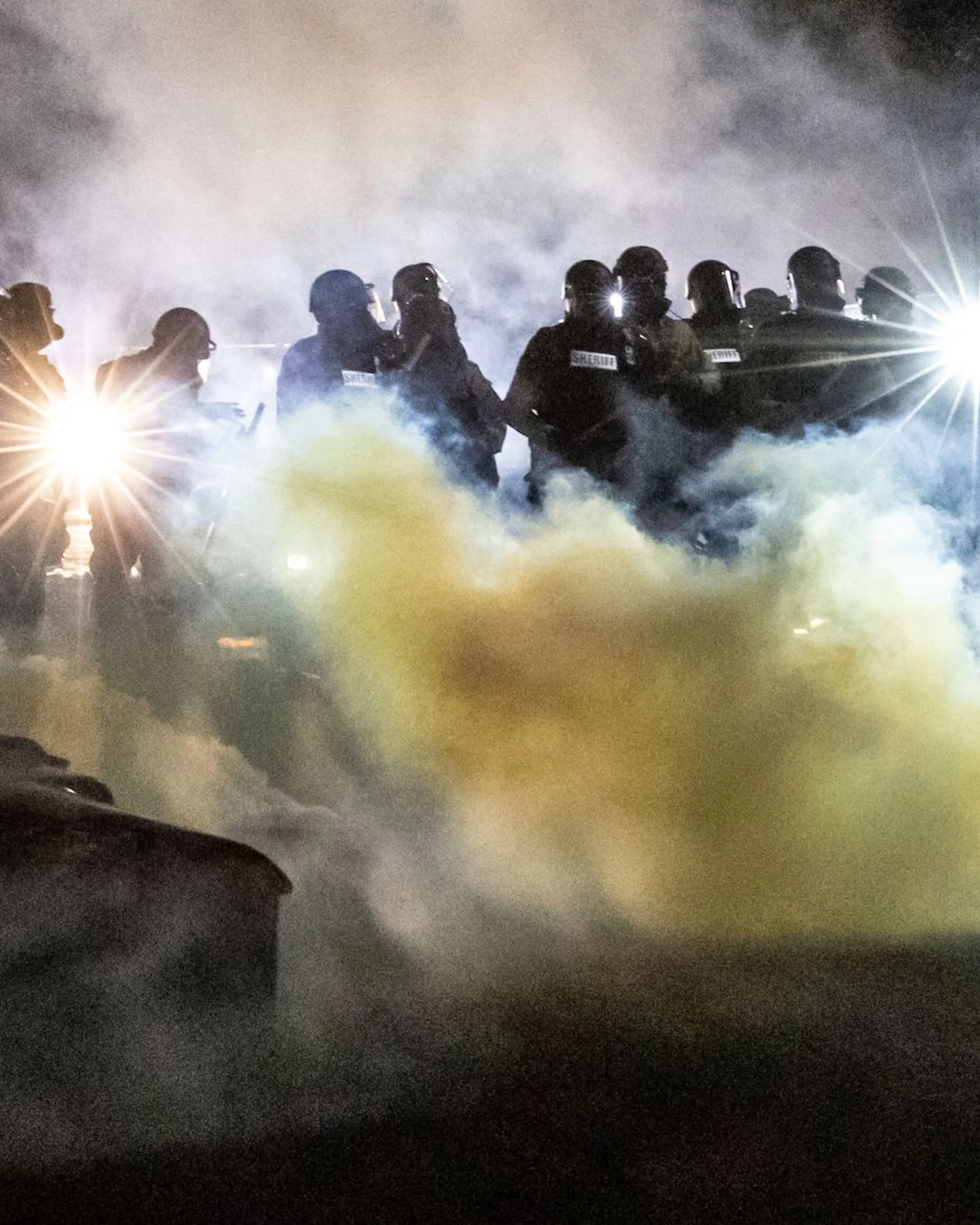 Minneapolis Riot Police officers in riot gear fire tear gas in front of the Brooklyn Center Police Station as people gather to protest after a police officer shot and killed a black man in Brooklyn Center, Minneapolis, Minnesota on April 11, 2021. - Protests broke out April 11, 2021 night after US police fatally shot a young Black man in a suburb of Minneapolis -- where a former police officer is currently on trial for the murder of George Floyd. Hundreds of people gathered outside the police station in Brooklyn Center, northwest of Minneapolis. Police fired teargas and flash bangs at the demonstrators, according to an AFP videojournalist at the scene. (Photo by Kerem Yucel / AFP)