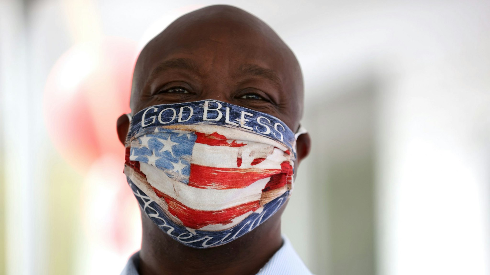 DOUGLASVILLE, GEORGIA - OCTOBER 28: U.S. Sen. Tim Scott (R-SC) wears a face mask that reads "God Bless America" during a campaign event with U.S. Sen. Kelly Loeffler (R-GA) at Metro Garage Door on October 28, 2020 in Douglasville, Georgia. Sen. Loeffler is running for re-election after being appointed by Georgia Governor Brian Kemp in January following the retirement of Sen. Johnny Isakson (R-GA).