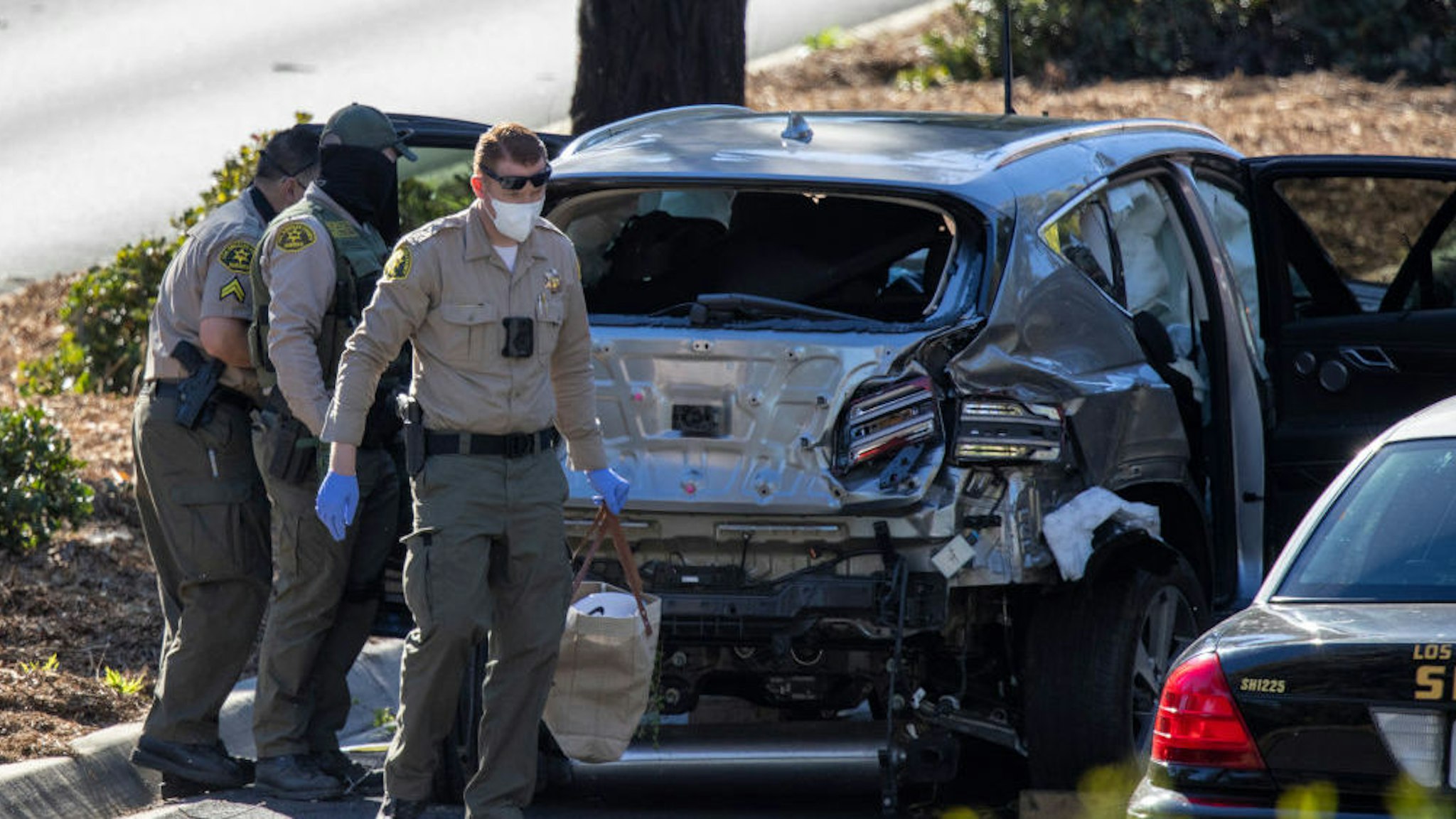 ROLLING HILLS ESTATES, CA - FEBRUARY 23: Los Angeles County Sheriff deputies gather evidence from the car that golf legend Tiger Woods was driving when seriously injured in a rollover accident on February 23, 2021 in Rolling Hills Estates, California. Rescuers used hydraulic rescue tools to extricate him from the car where he reportedly sustained major leg injuries. Law enforcement reports that there was no evidence of impairment. He was in town to participate in The Genesis Invitational golf tournament.