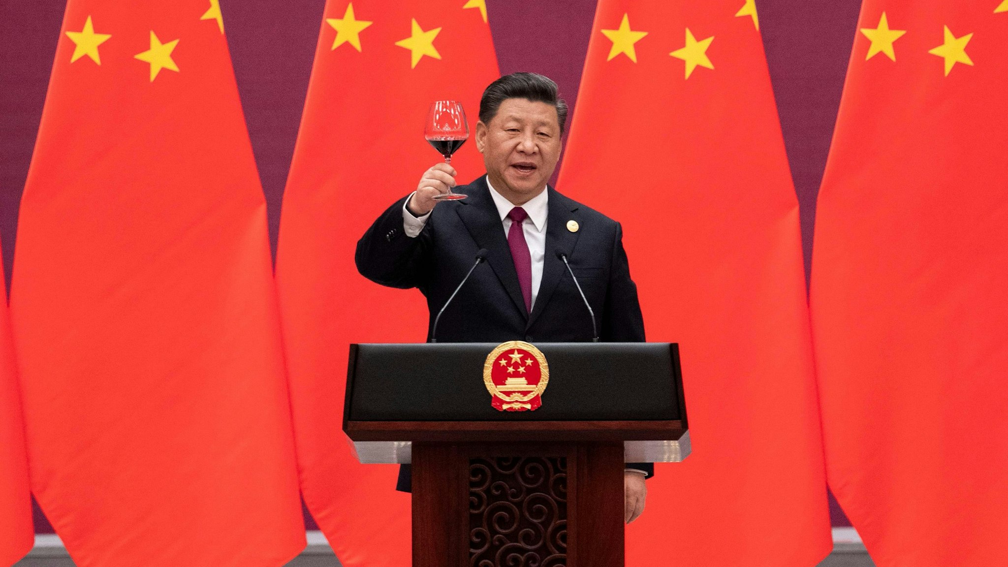 TOPSHOT - China's President Xi Jinping raises his glass and proposes a toast at the end of his speech during the welcome banquet for leaders attending the Belt and Road Forum at the Great Hall of the People in Beijing on April 26, 2019.