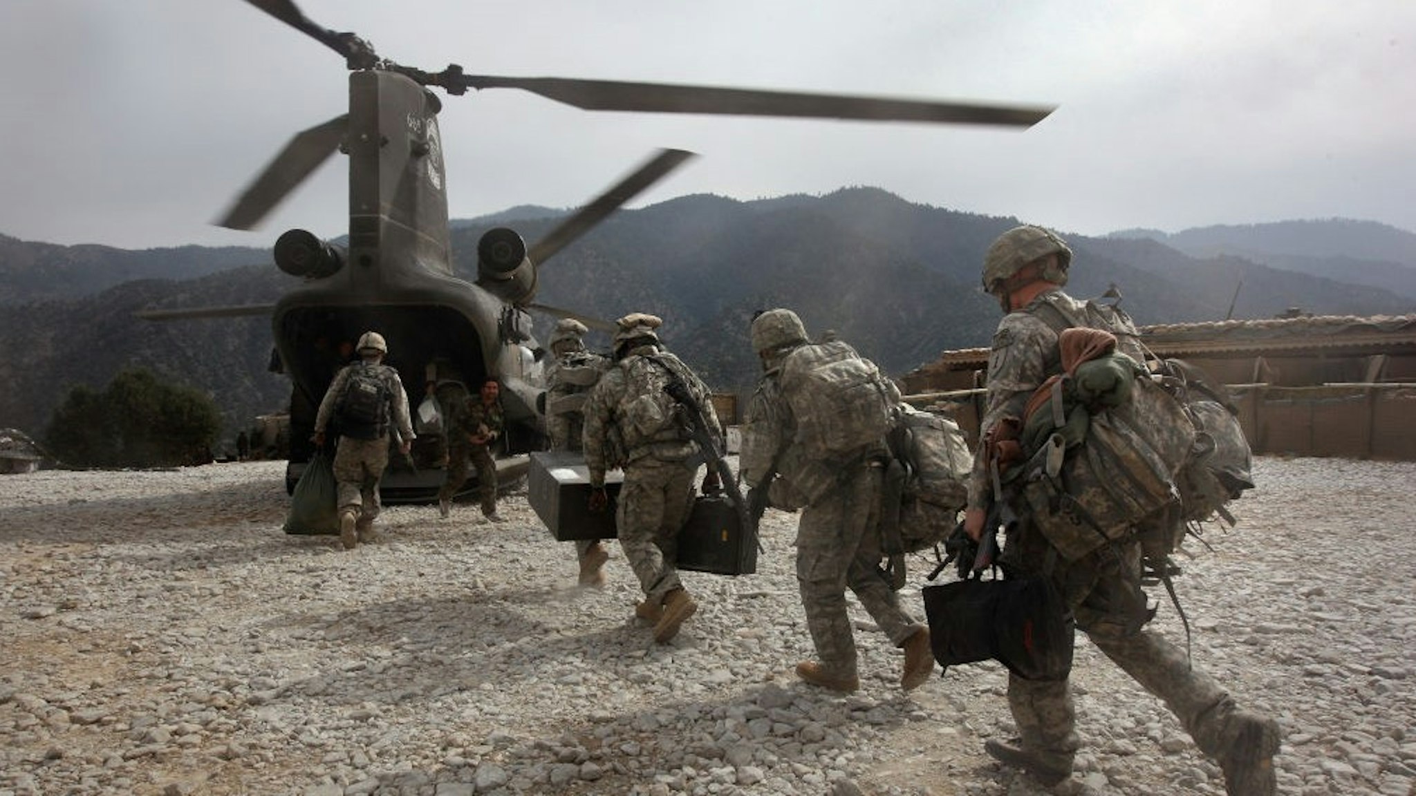 KORENGAL VALLEY, AFGHANISTAN - OCTOBER 27: U.S. soldiers board an Army Chinook transport helicopter after it brought fresh soldiers and supplies to the Korengal Outpost on October 27, 2008 in the Korengal Valley, Afghanistan. The military spends huge effort and money to fly in supplies to soldiers of the 1-26 Infantry based in the Korengal Valley, site of some of the fiercest fighting of the Afghan war. The unpaved road into the remote area is bad and will become more treacherous with the onset of winter. (Photo by