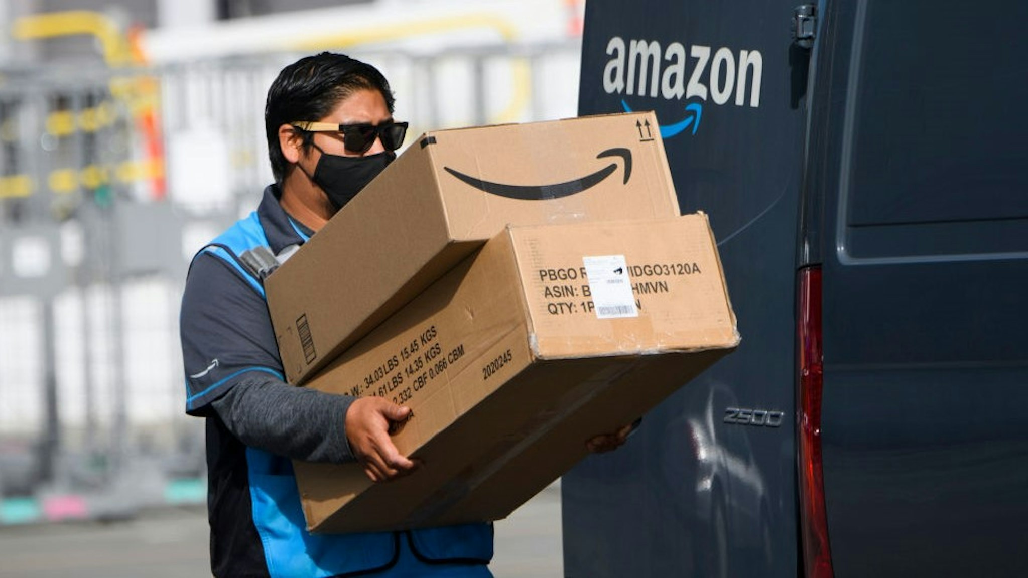 An Amazon.com Inc. delivery driver carries boxes into a van outside of a distribution facility on February 2, 2021 in Hawthorne, California. - Jeff Bezos said February 1, 2021, he would give up his role as chief executive of Amazon later this year as the tech and e-commerce giant reported a surge in profit and revenue in the holiday quarter. The announcement came as Amazon reported a blowout holiday quarter with profits more than doubling to $7.2 billion and revenue jumping 44 percent to $125.6 billion. (Photo by Patrick T. FALLON / AFP) (Photo by