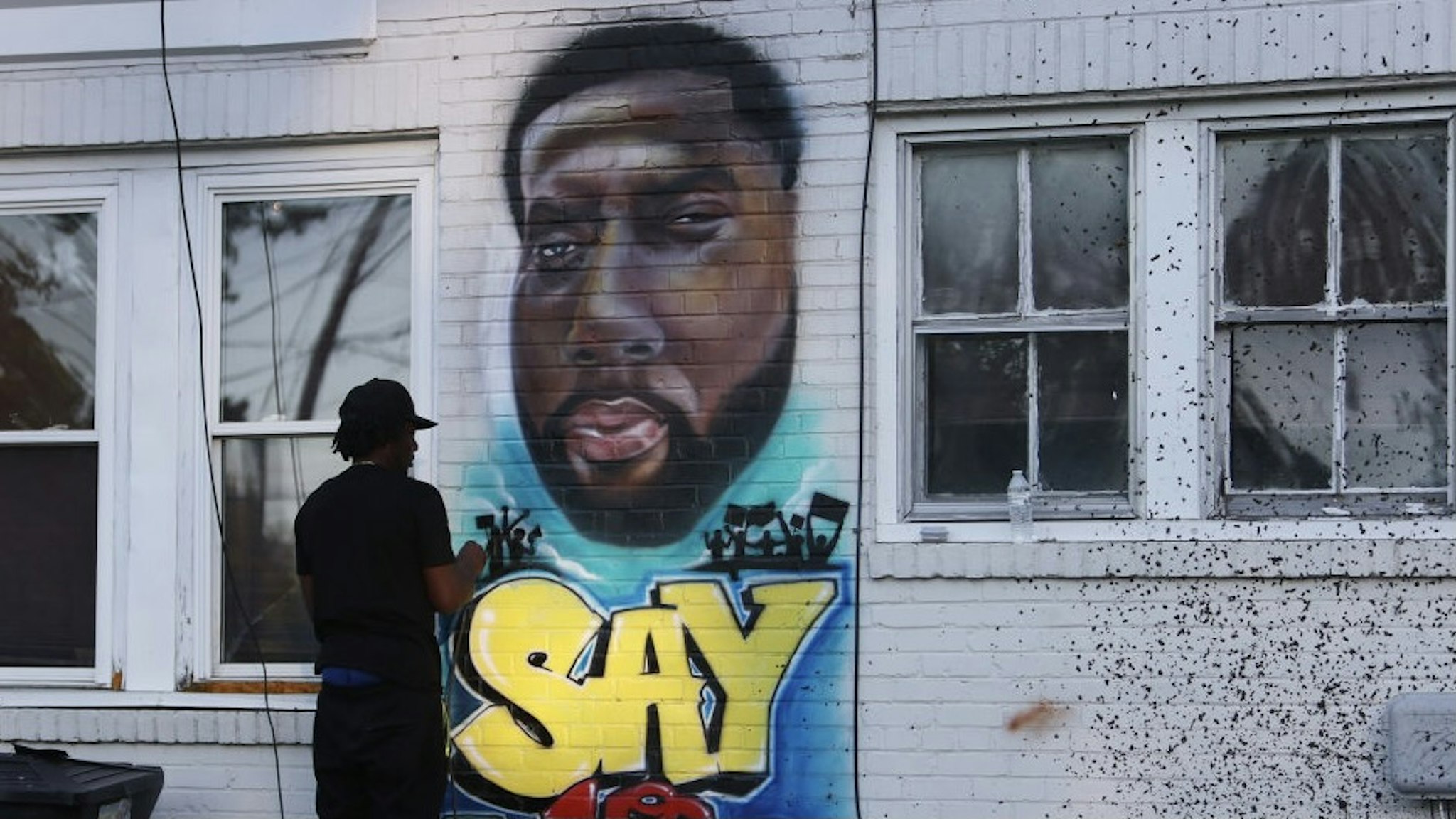 ELIZABETH CITY, NORTH CAROLINA - MAY 01: Ulysses Edwards paints a portrait of Andrew Brown Jr. on the side of the house in the area where he was killed on May 01, 2021 in Elizabeth City, North Carolina. Mr. Brown was shot to death by Pasquotank County Sheriff's deputies. (Photo by Joe Raedle/Getty Images)