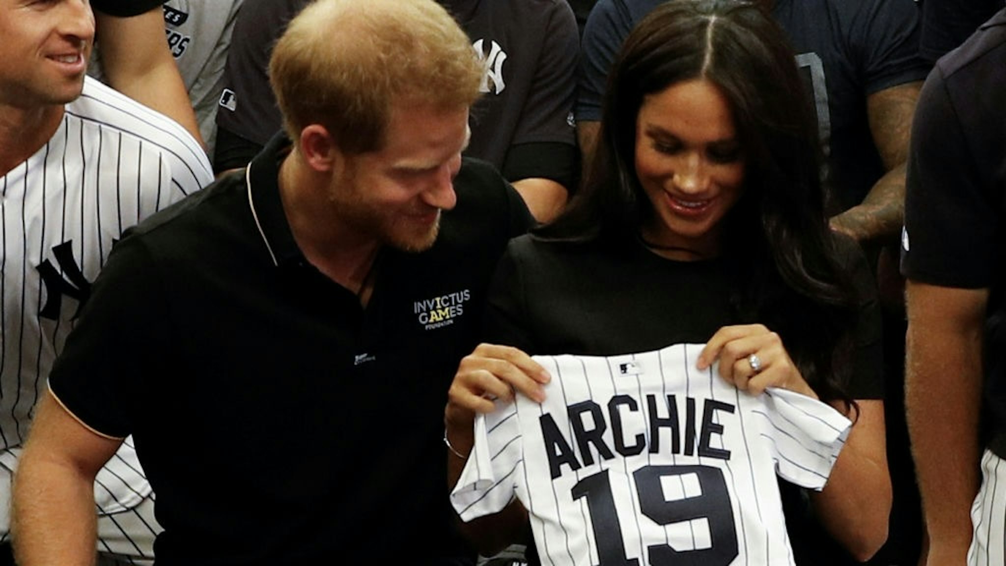 Britain's Prince Harry, Duke of Sussex, and his wife Meghan, Duchess of Sussex react as they are presented with gifts for her newborn son Archie, as they meet New York Yankees players ahead of their match against the Boston Red Sox at the London Stadium in Queen Elizabeth Olympic Park, east London on June 29, 2019, for the first of a two-game Baseball series in London. - As Major League Baseball prepares to make history in London, New York Yankees manager Aaron Boone and Boston Red Sox coach Alex Cora are united in their desire to make the ground-breaking trip memorable on and off the field. (Photo by PETER NICHOLLS / POOL / AFP) (Photo credit should read PETER NICHOLLS/AFP via Getty Images)