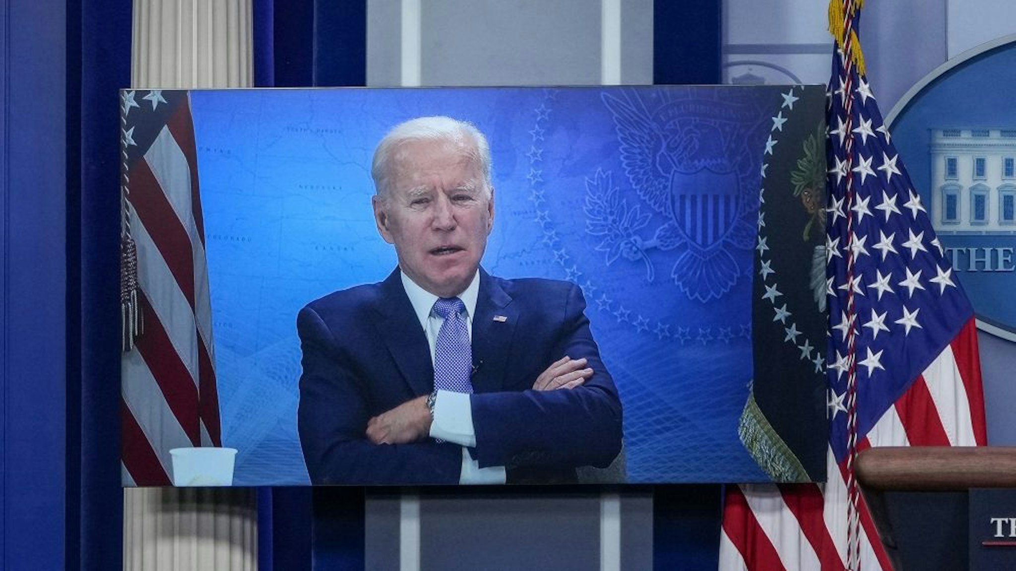 WASHINGTON, DC - MAY 11: President Joe Biden is displayed on a monitor in the press briefing room while he attends a virtual meeting with governors at the White House on May 11, 2021 in Washington, DC. Biden met with a bipartisan group of six governors to discuss best practices in vaccinating citizens for COVID-19.