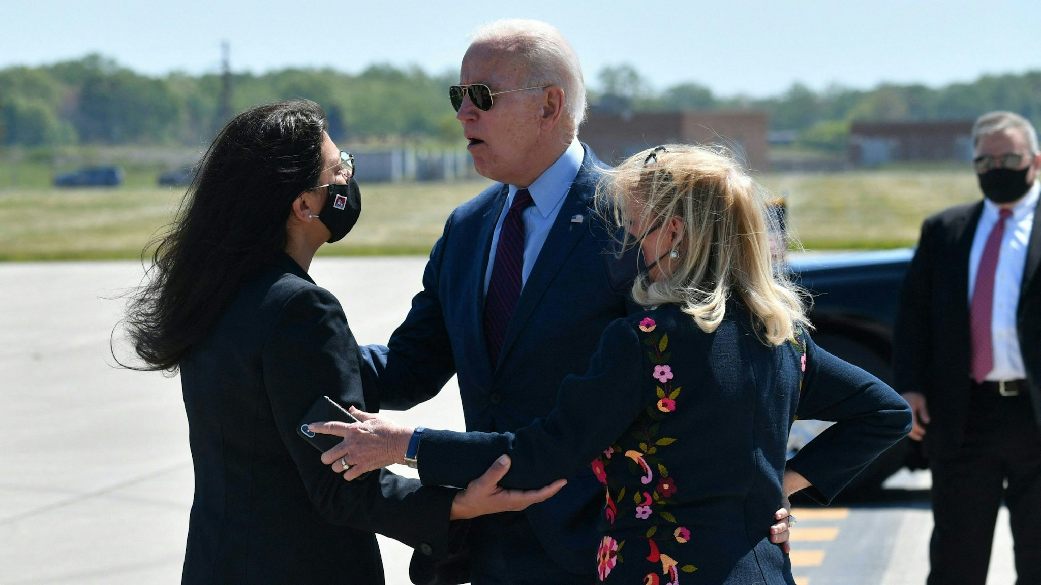 US President Joe Biden speaks with Representative Rashida Taib (D-Mich), and Representative Debbie Dingell (D-Mich)(R), as he arrives at Detroit, Metropolitan Wayne County Airport in Detroit, Michigan on May 18, 2021.