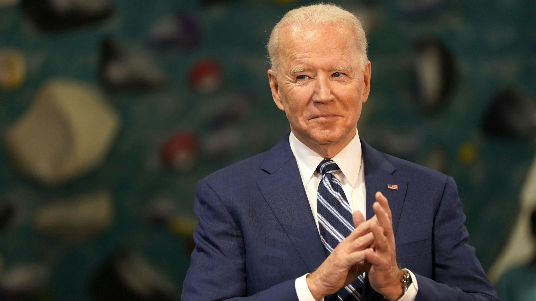 U.S. President Joe Biden applauds while Ralph Northam, governor of Virginia, not pictured, speaks at Sportrock Climbing Center during an event in Alexandria, Virginia, U.S., on Friday, May 28, 2021. Biden this week said he ordered the U.S. intelligence community to "redouble" its effort to determine where the coronavirus came from, after conflicting conclusions about whether its origins are natural or a lab accident.