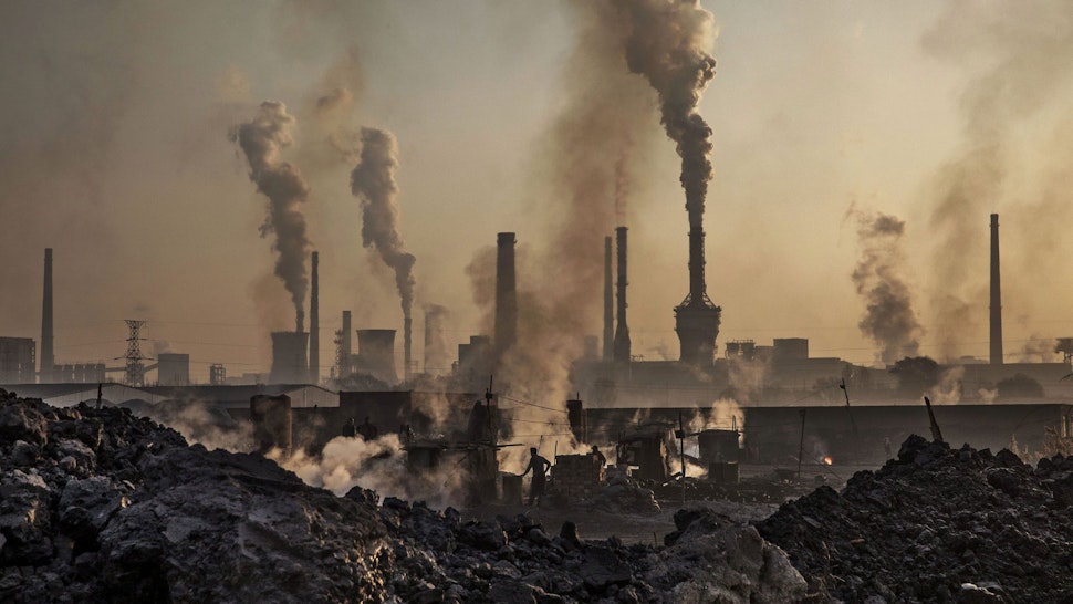 INNER MONGOLIA, CHINA - NOVEMBER 04: Smoke billows from a large steel plant as a Chinese labourer works at an unauthorized steel factory, foreground, on November 4, 2016 in Inner Mongolia, China. To meet China's targets to slash emissions of carbon dioxide, authorities are pushing to shut down privately owned steel, coal, and other high-polluting factories scattered across rural areas. In many cases, factory owners say they pay informal 'fines' to local inspectors and then re-open. The enforcement comes as the future of U.S. support for the 2015 Paris Agreement is in question, leaving China poised as an unlikely leader in the international effort against climate change. U.S. president-elect Donald Trump has sent mixed signals about whether he will withdraw the U.S. from commitments to curb greenhouse gases that, according to scientists, are causing the earth's temperature to rise. Trump once declared that the concept of global warming was "created" by China in order to hurt U.S. manufacturing. China's leadership has stated that any change in U.S. climate policy will not affect its commitment to implement the climate action plan. While the world's biggest polluter, China is also a global leader in establishing renewable energy sources such as wind and solar power.