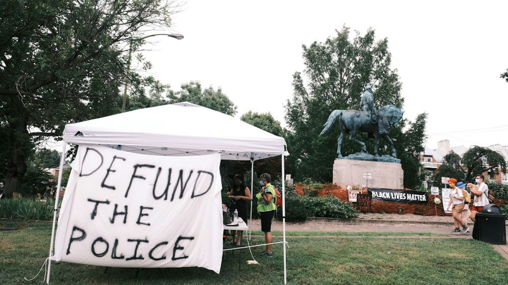 CHARLOTTESVILLE, VA - AUGUST 12: A banner that reads "Defund The Police" is seen during the "Reclaim the Park" gathering at Emancipation Park on August 12, 2020 in Charlottesville, Virginia. Community members in Charlottesville collaborated with Congregate Cville and other Charlottesville organizations to put together the "Reclaim the Park" gathering to mark the third anniversary of a far-right rally on August 12, 2017.