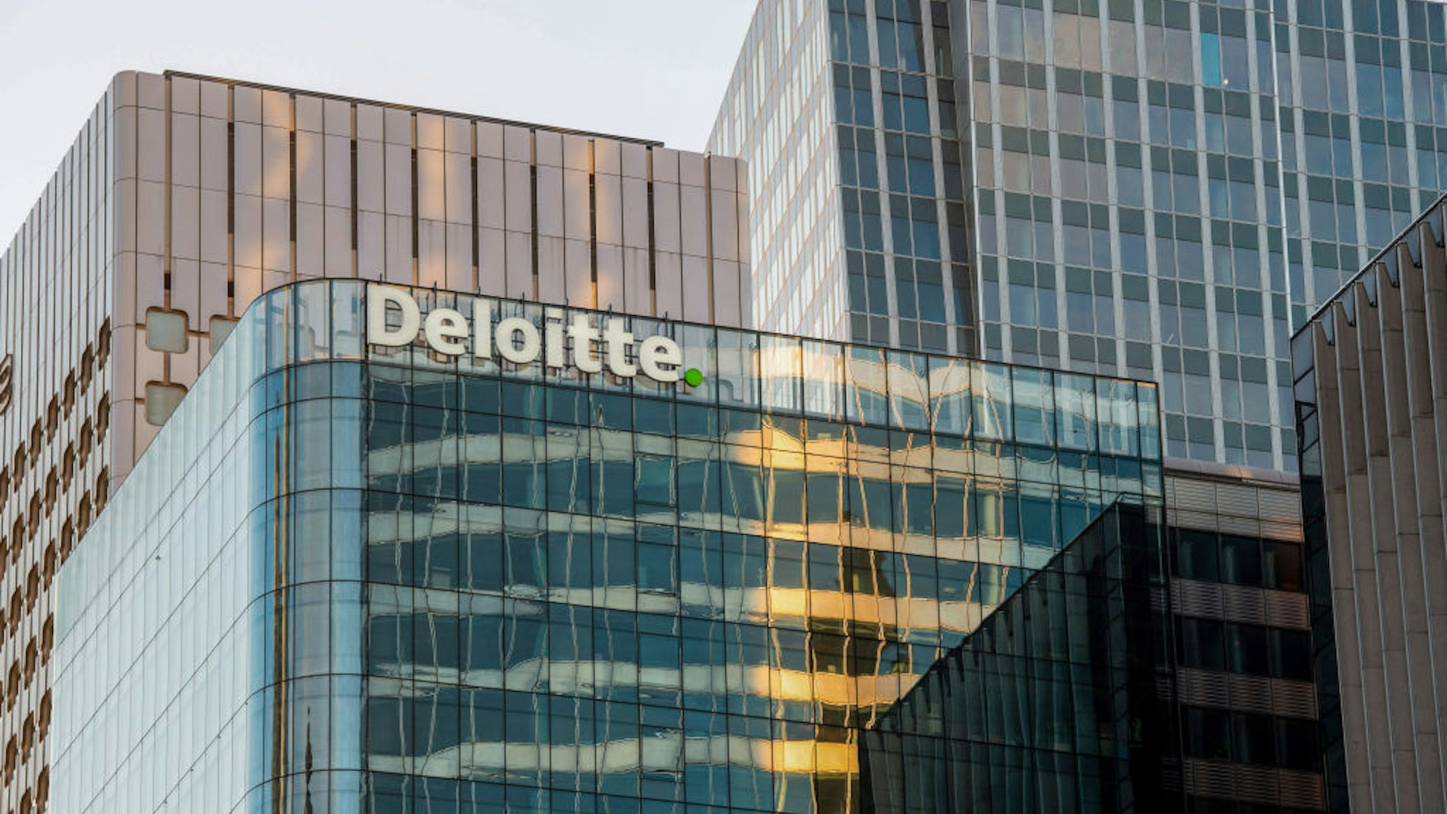The Deloitte logo outside the Deloitte LLP office building in the La Defense business district of Paris, France, on Monday, Nov. 9, 2020. France's economy will take a smaller hit from the new lockdown to contain the spread of Covid-19 than it did during the tighter restrictions on activity earlier this year, according to the countrys central bank.