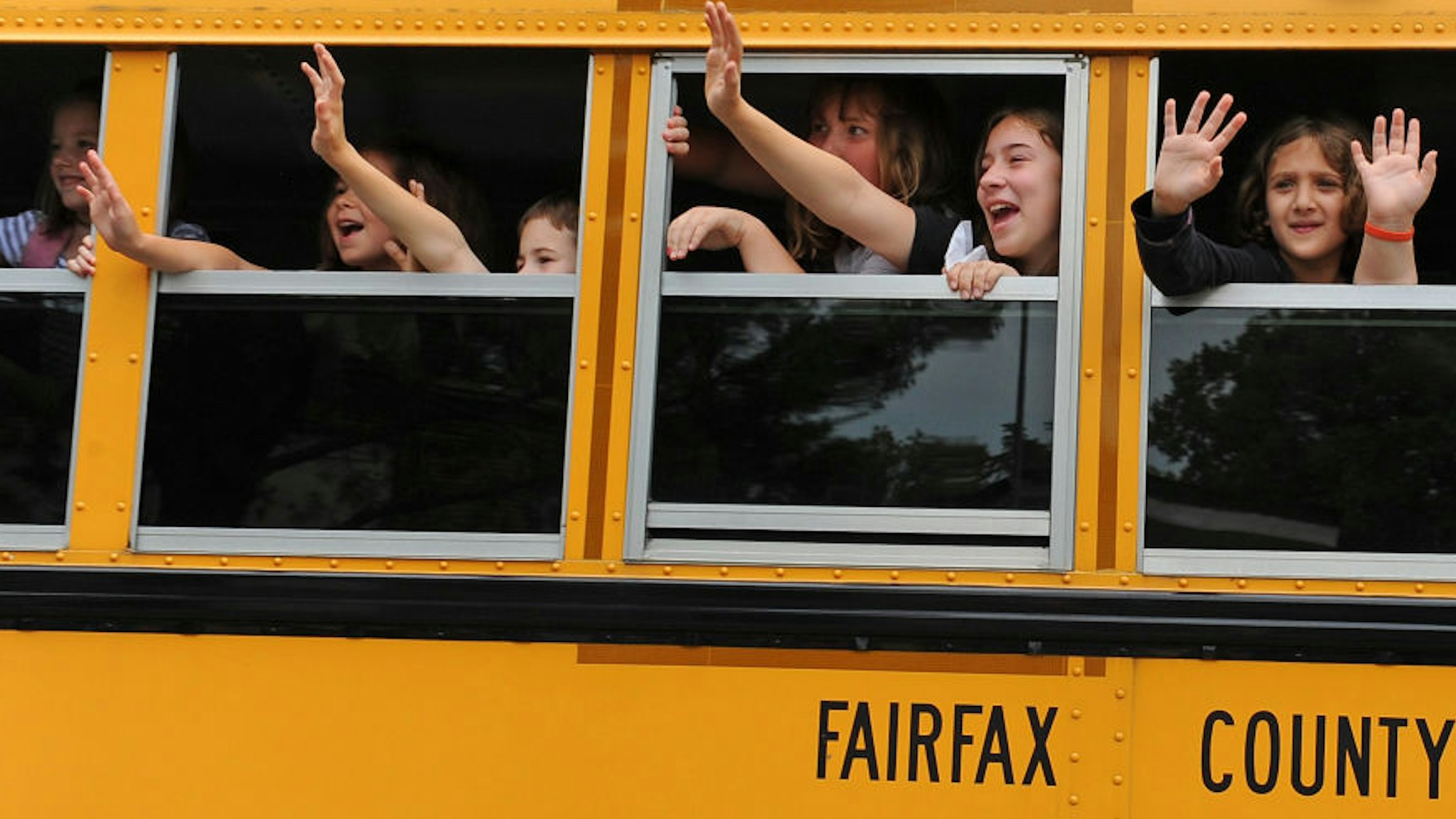 CLIFTON, VA - JUNE 21: Students aboard a school bus wave bye to their teachers at the end of classes during the last day of school at Clifton Elementary School on June 21, 2011 in Clifton, Va. The school is permanently closing its doors because of county boundary changes. Clifton is one of the most rural areas in Fairfax County bringing in kids from one tenth of the county's size. The closing of the school is so controversial that the decision is the subject of a lawsuit in front of the state Supreme Court.