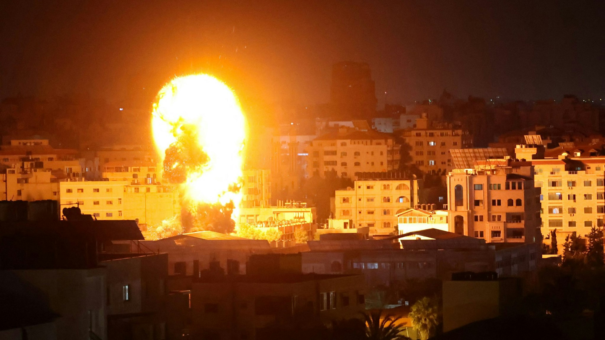 Fire and smoke rise above buildings in Gaza City as Israeli warplanes target the Palestinian enclave, early on May 17, 2021. - Israeli warplanes bombarded the Gaza Strip overnight, said witnesses in the Palestinian enclave, from where armed groups have launched rockets into the Jewish state.