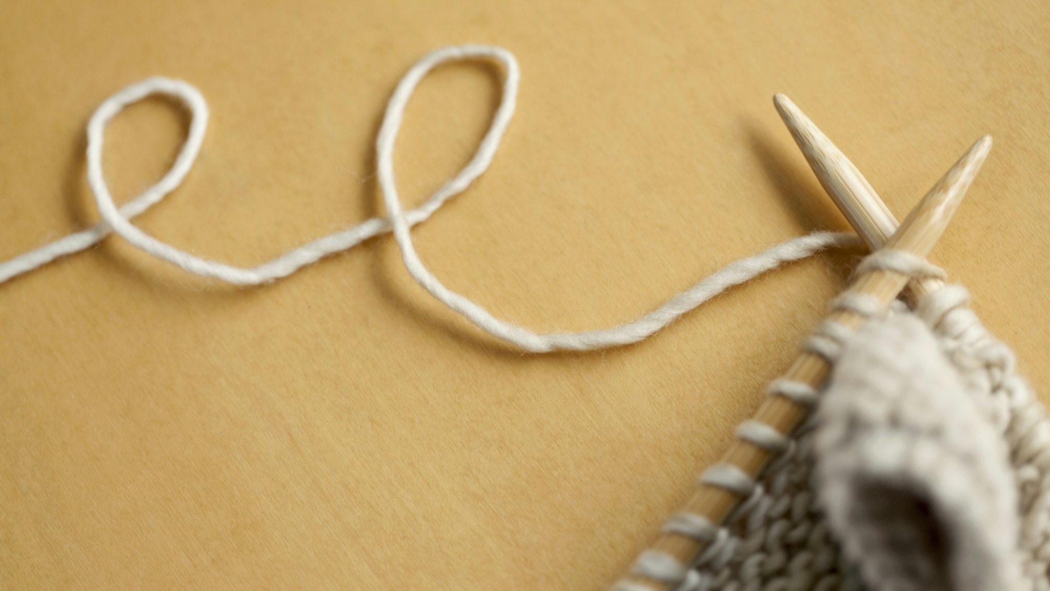line of wool string connected to knitting project - stock photo