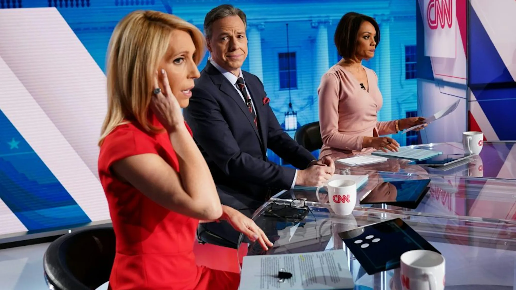 CNN CNN news anchor Jake Tapper (C), flanked by Univision's news anchor Ilia Calderón (R), watches as co-anchor Dana Bash adjusts her ear piece before the start of the 11th Democratic Party 2020 presidential debate with former Vice-President Joe Biden and Vermont Senator Bernie Sanders in a CNN Washington Bureau studio in Washington, DC on March 15, 2020.
