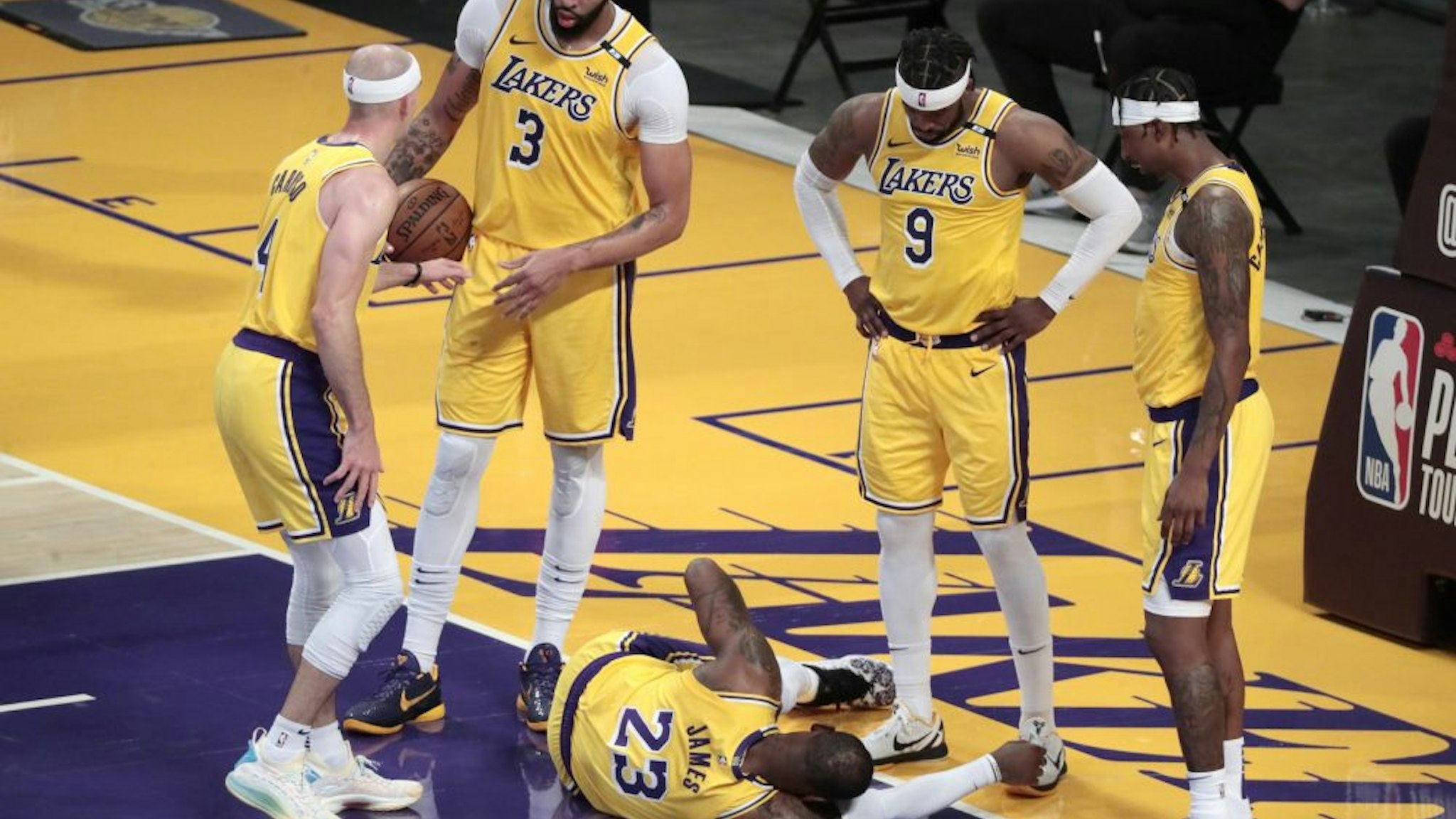 Los Angeles, CA, Wednesday, May 19, 2021 _ Teammates gather around Los Angeles Lakers forward LeBron James (23) as he lays stunned after taking a hard foul from Golden State Warriors forward Draymond Green (23) in the second half of a Pay-In game at Staples Center.