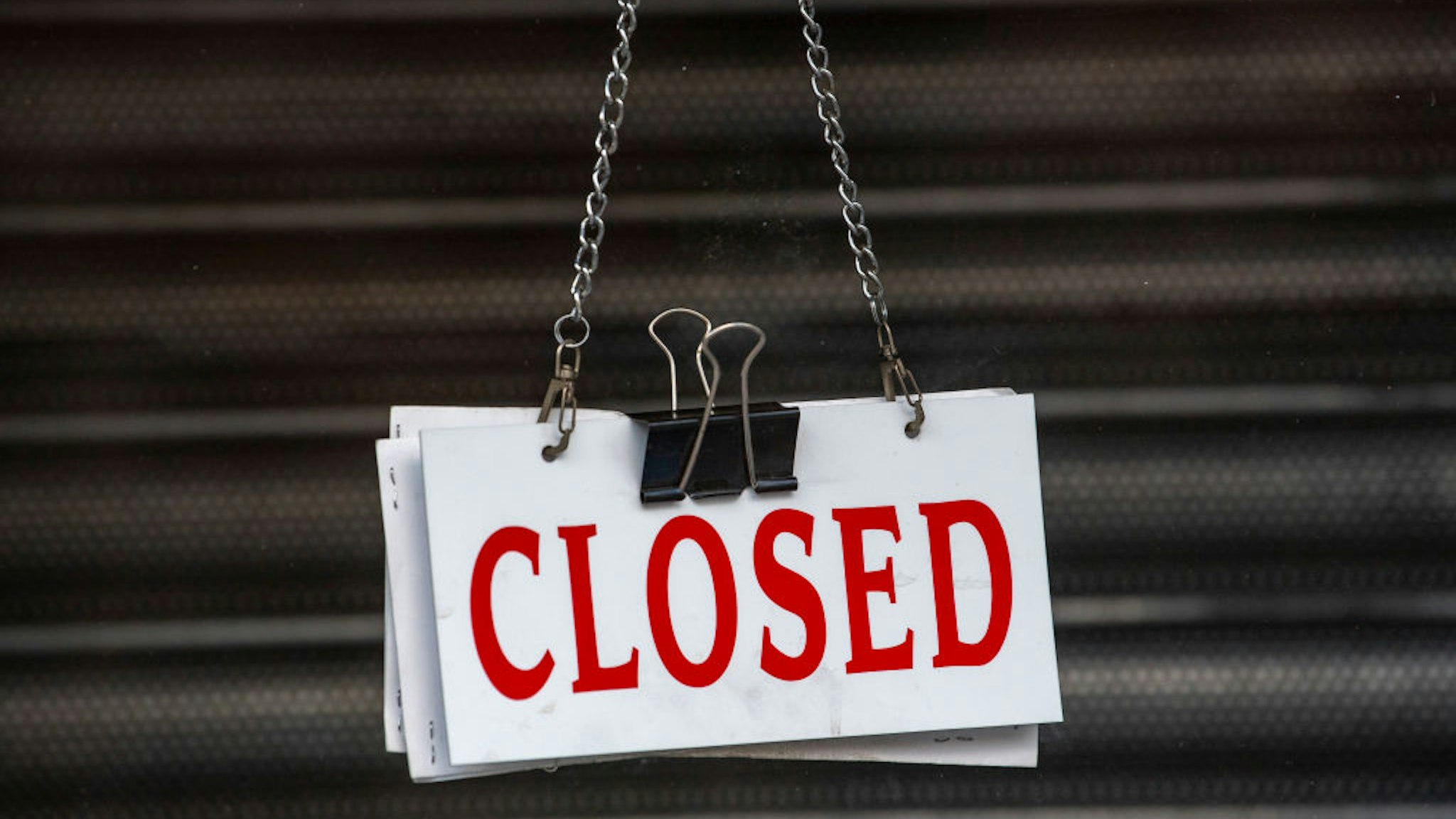 CARDIFF, UNITED KINGDOM - JUNE 20: A closed sign hanging in the window of a closed small business on June 20, 2020 in Cardiff, United Kingdom. The First Minister of Wales Mark Drakeford has continued the easing of the lockdown in Wales, announcing that all non-essential shops will be allowed to open their doors again and outdoor sports courts can re-open. Team and contact sports will not be permitted and playgrounds will remain closed. People will be asked to continue to "stay local" with five miles given as guidance until July 6.