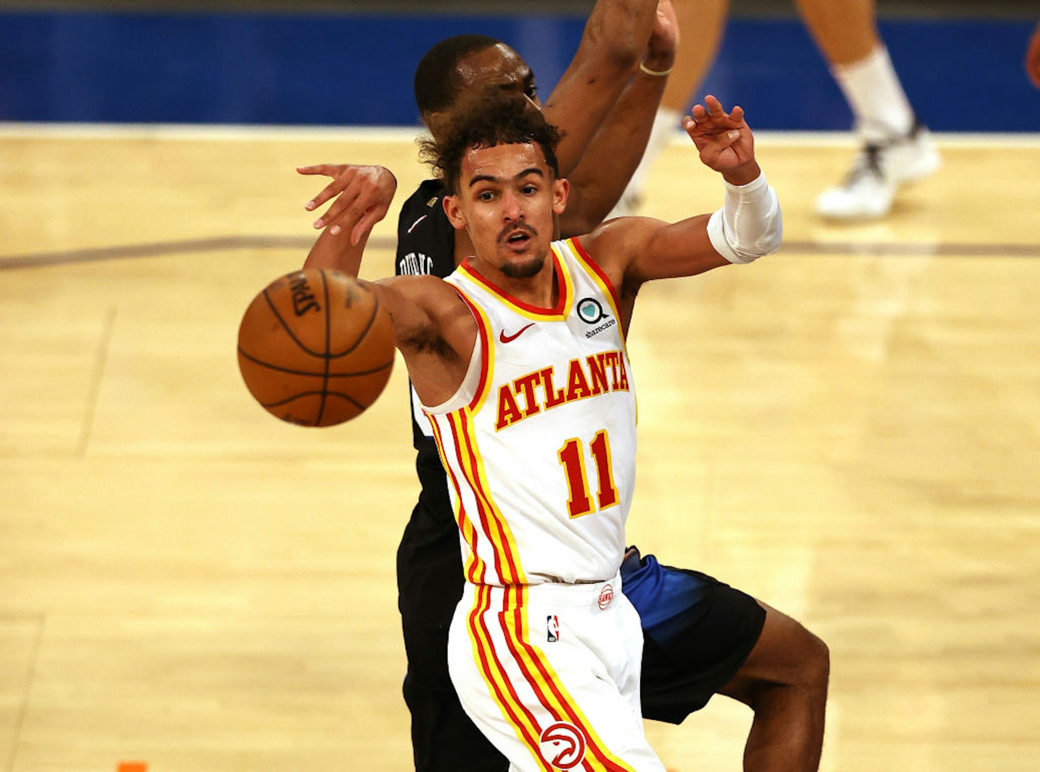 NEW YORK, NEW YORK - MAY 26: Trae Young #11 of the Atlanta Hawks passes the ball as Alec Burks #18 of the New York Knicks defends in the fourth quarter during game two of the Eastern Conference Quarterfinals at Madison Square Garden on May 26, 2021 in New York City.The New York Knicks defeated the Atlanta Hawks 101-92. NOTE TO USER: User expressly acknowledges and agrees that, by downloading and or using this photograph, User is consenting to the terms and conditions of the Getty Images License Agreement. (Photo by Elsa/Getty Images)