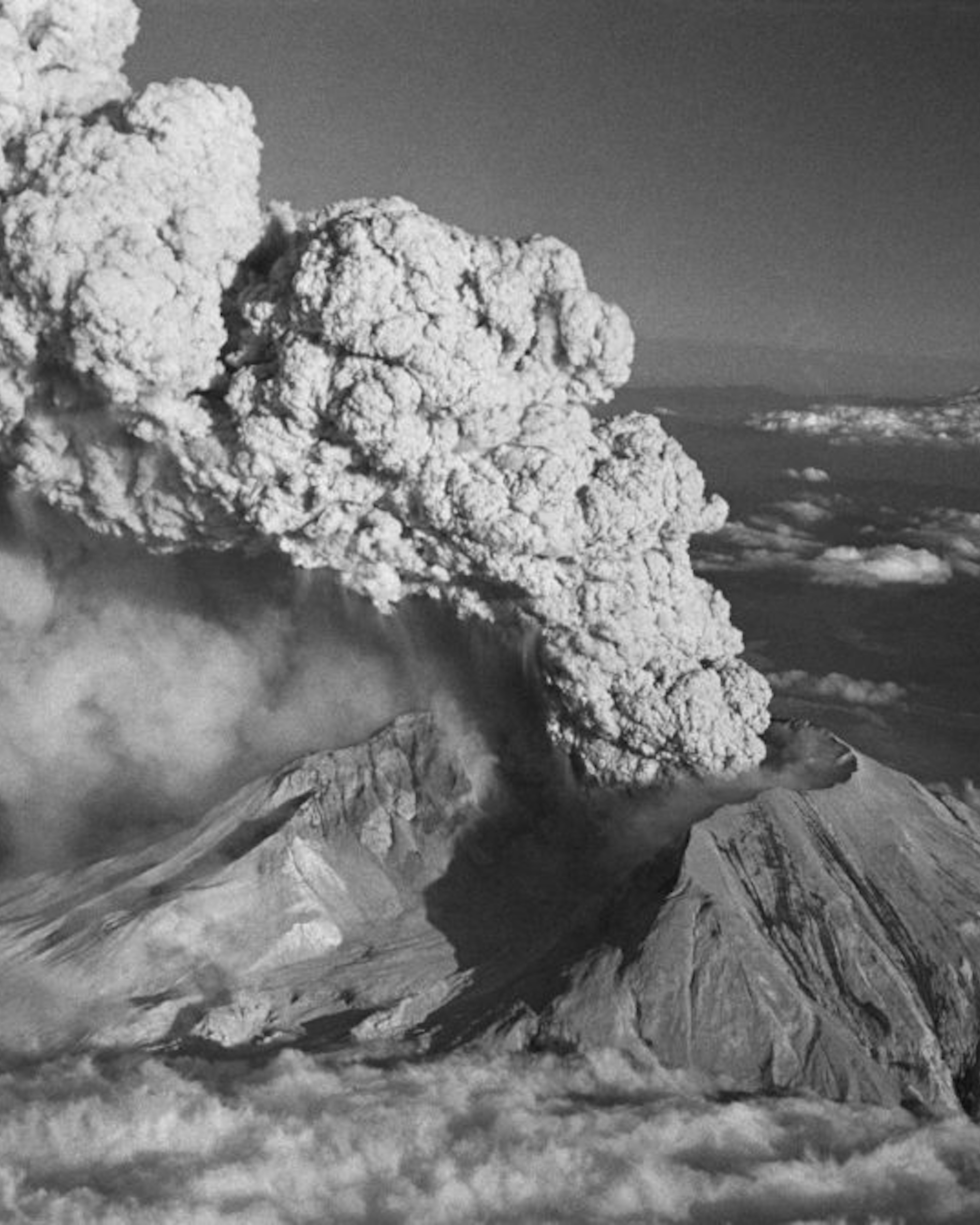 (Original Caption) "BLOWS TOP AGAIN." SPIRIT LAKE,WASH.: WITH MOUNT HOOD (RIGHT,REAR) VISIBLE IN THE BACKGROUND, MOUNT ST.HELENS ERUPTS JULY 22. THE PLUME OF STEAM AND ASH ROSE SOME 60,000 FEET IN THE AIR, SENDING ASH IN A NORTHEASTERLY DIRECTION. MOUNT ST.HELENS BROKE A SIX-WEEK SILENCE WITH A SERIES OF TOWERING ASH ERUPTIONS. JULY 29,1980.